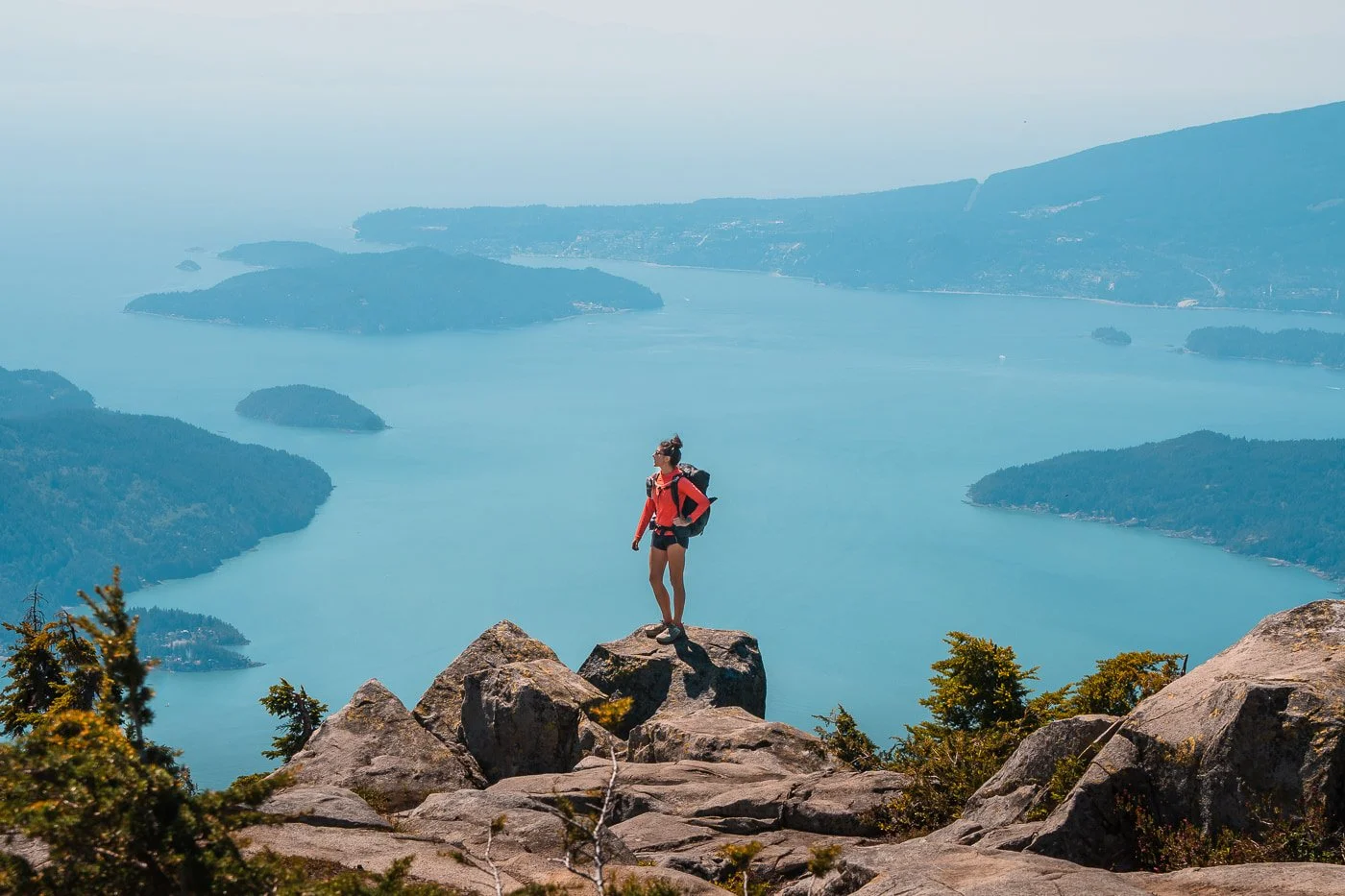 Girl standing on top of boulder overlooking the Howe Sound along the Howe Sound Crest Trail