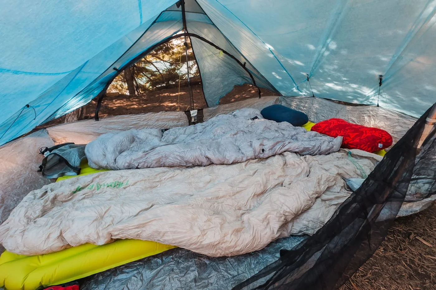 looking inside of a backpacking tent with quilts and pillows