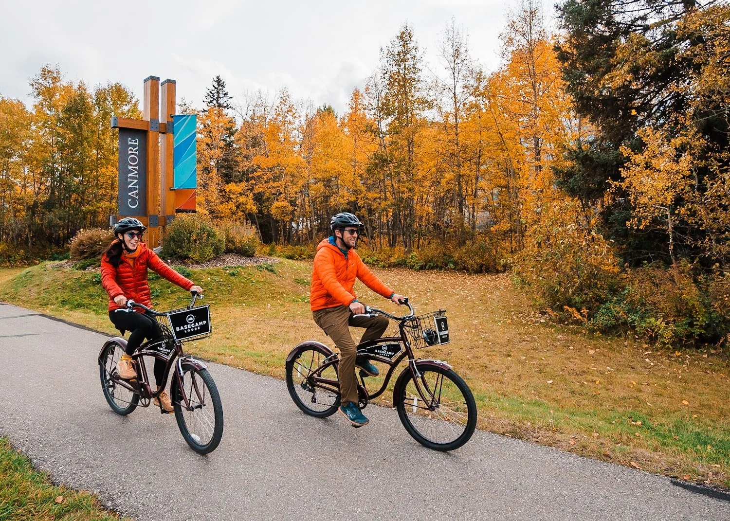 a couple riding bikes in Canmore with fall colors in the background