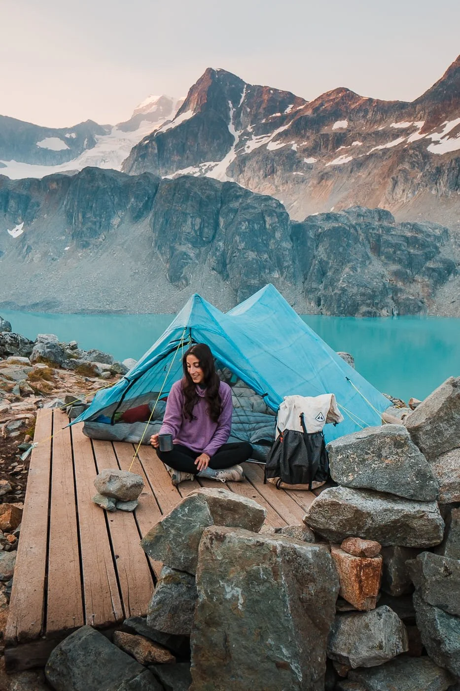  girl sitting on a tent platform at the upper wedgemount lake camping area 
