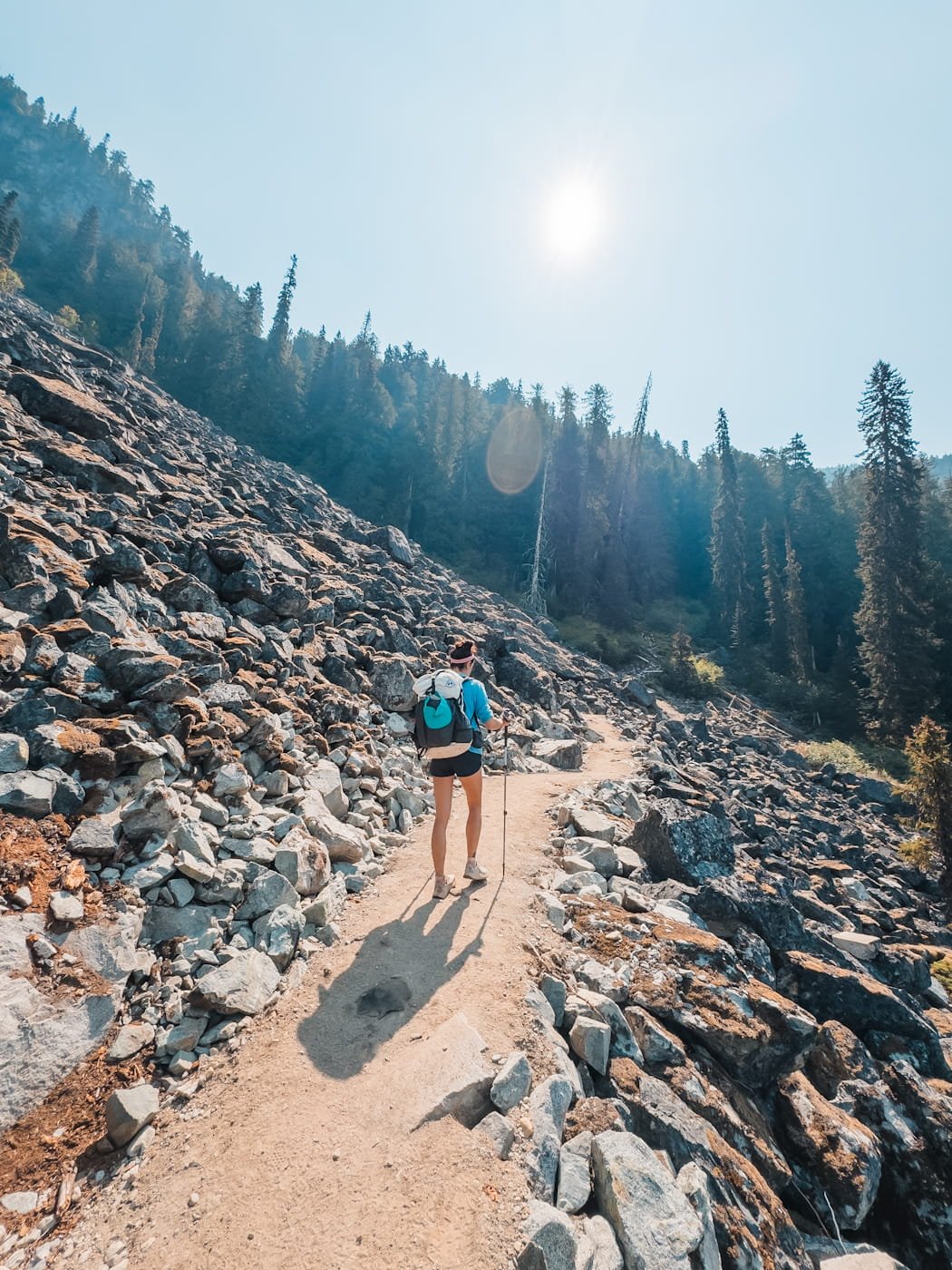 female backpacker along the lower new trail section and boulder field of the Wedgemount Lake trail 