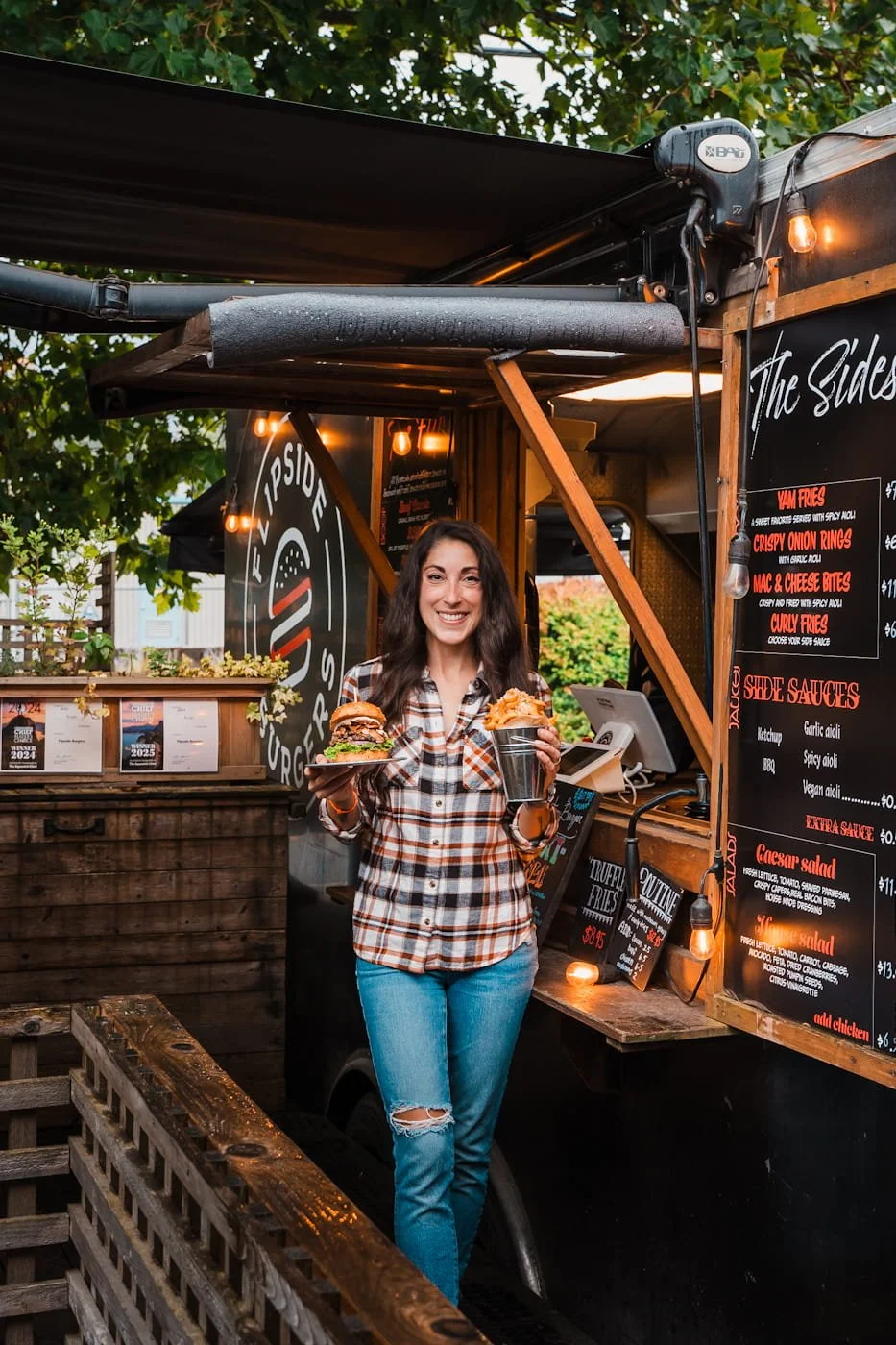 Girl holding burgers in front of Flipside Burgers food truck in Squamish BC
