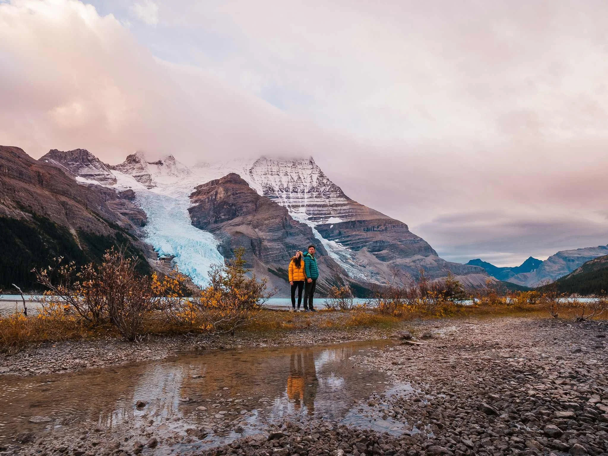 couple standing along the shore of Berg Lake