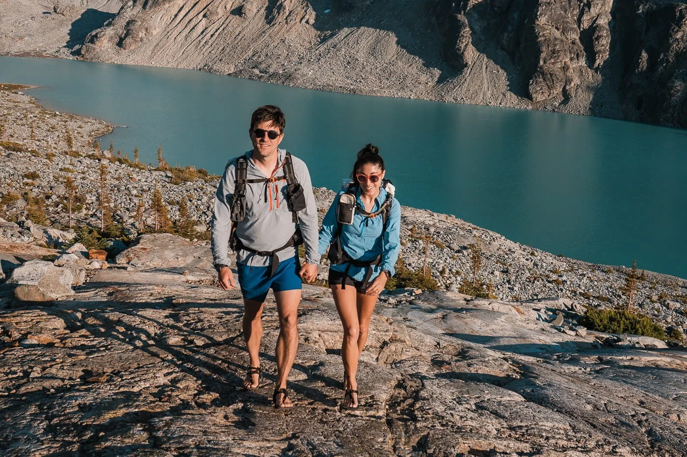 a man and woman enjoying a brisk walk up the rock slabs above Wedgemount Lake