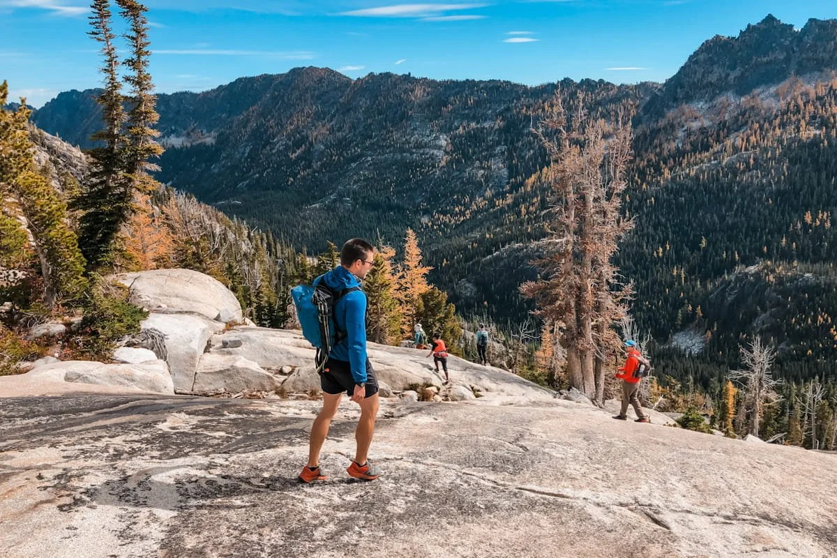 Day hikers heading down rock slabs out of the core enchantments en route to upper snow lakes