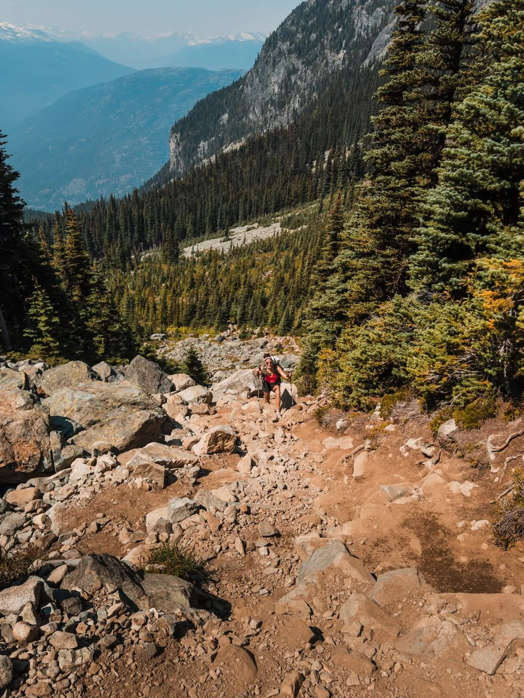  female backpacker climbing up the last steep rock gully to Wedgemount Lake 