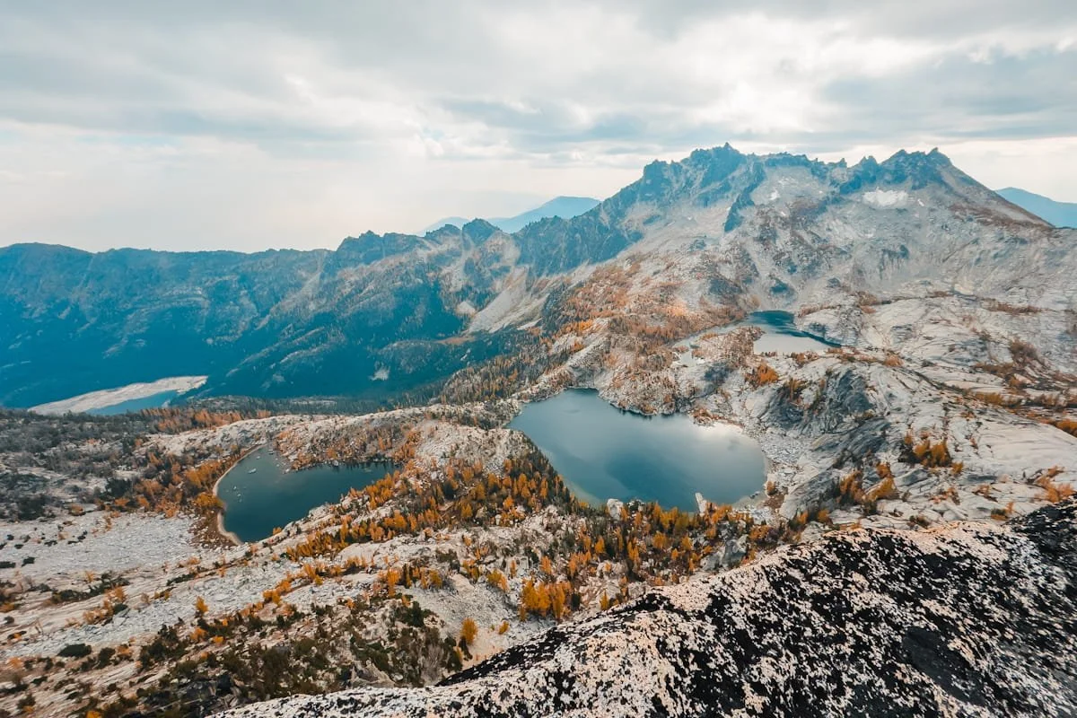 Looking down at the core enchantment lakes and peaks, blue alpine lakes, rocky peaks, and golden larch trees