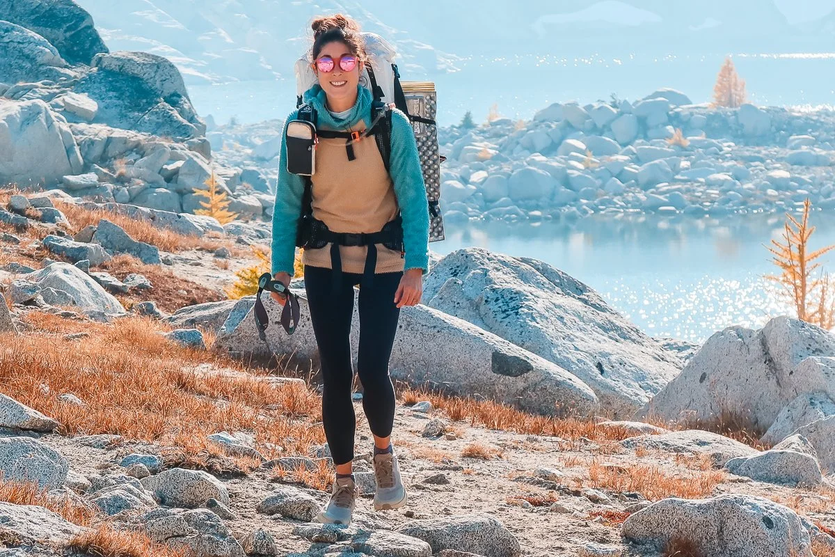 a woman backpacking in the core enchantments wearing an alpha cruiser fleece hoodie, leggings, and a hyperlite backpack