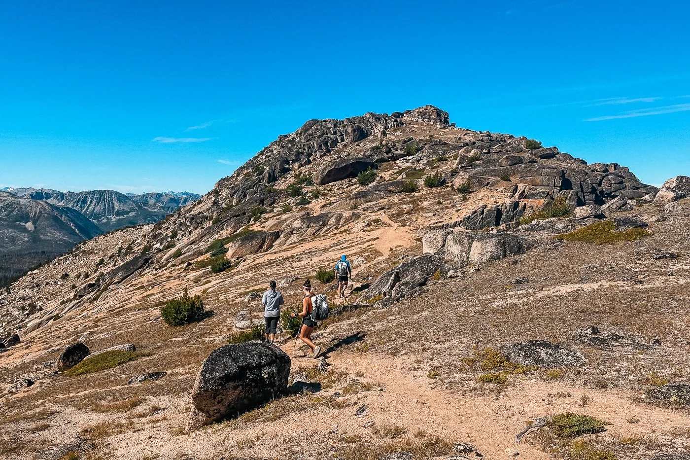 hikers heading up the trail to the summit of amphitheater mountain with a rocky trail and summit in the distance