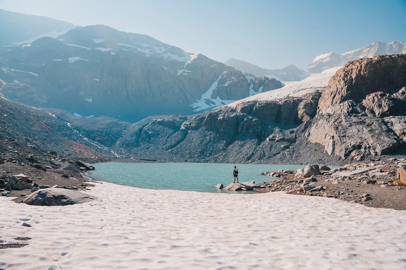 backpacker standing on the shore of tupper lake in Garabaldi Provincial Park