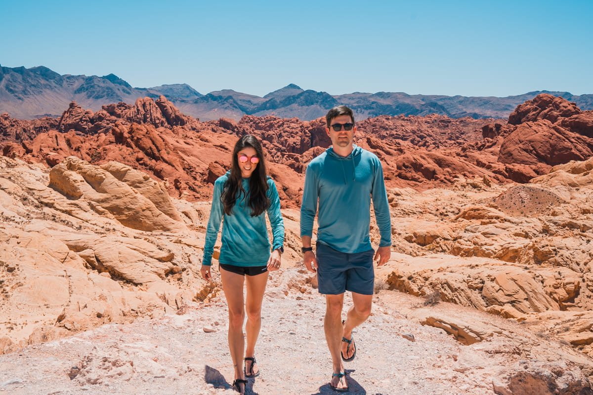 man and woman walking in desert with ridge merino solstice sun hoodies