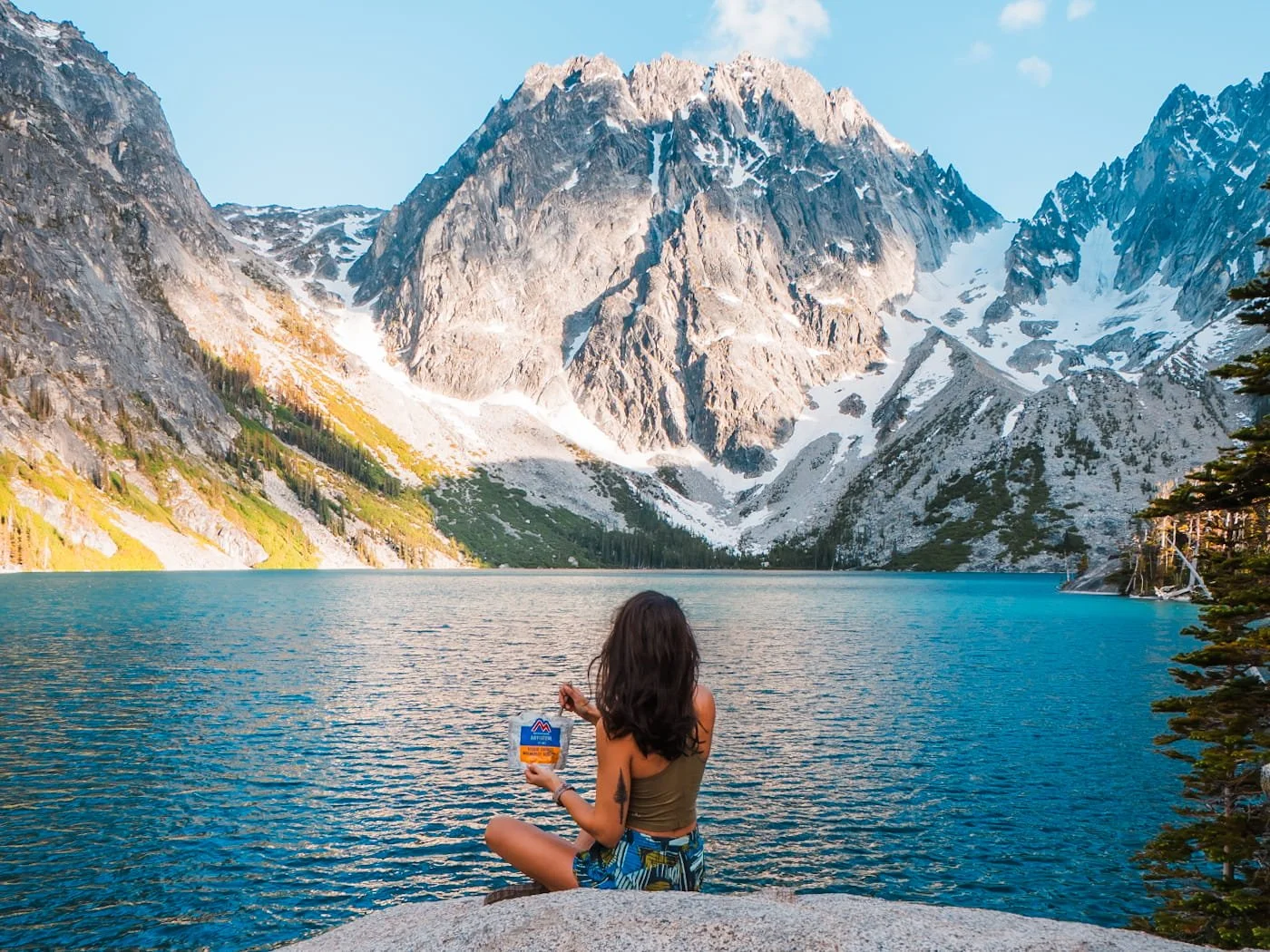 a girl enjoying dinner on the shore of Colchuck Lake near Leavenworth Washington
