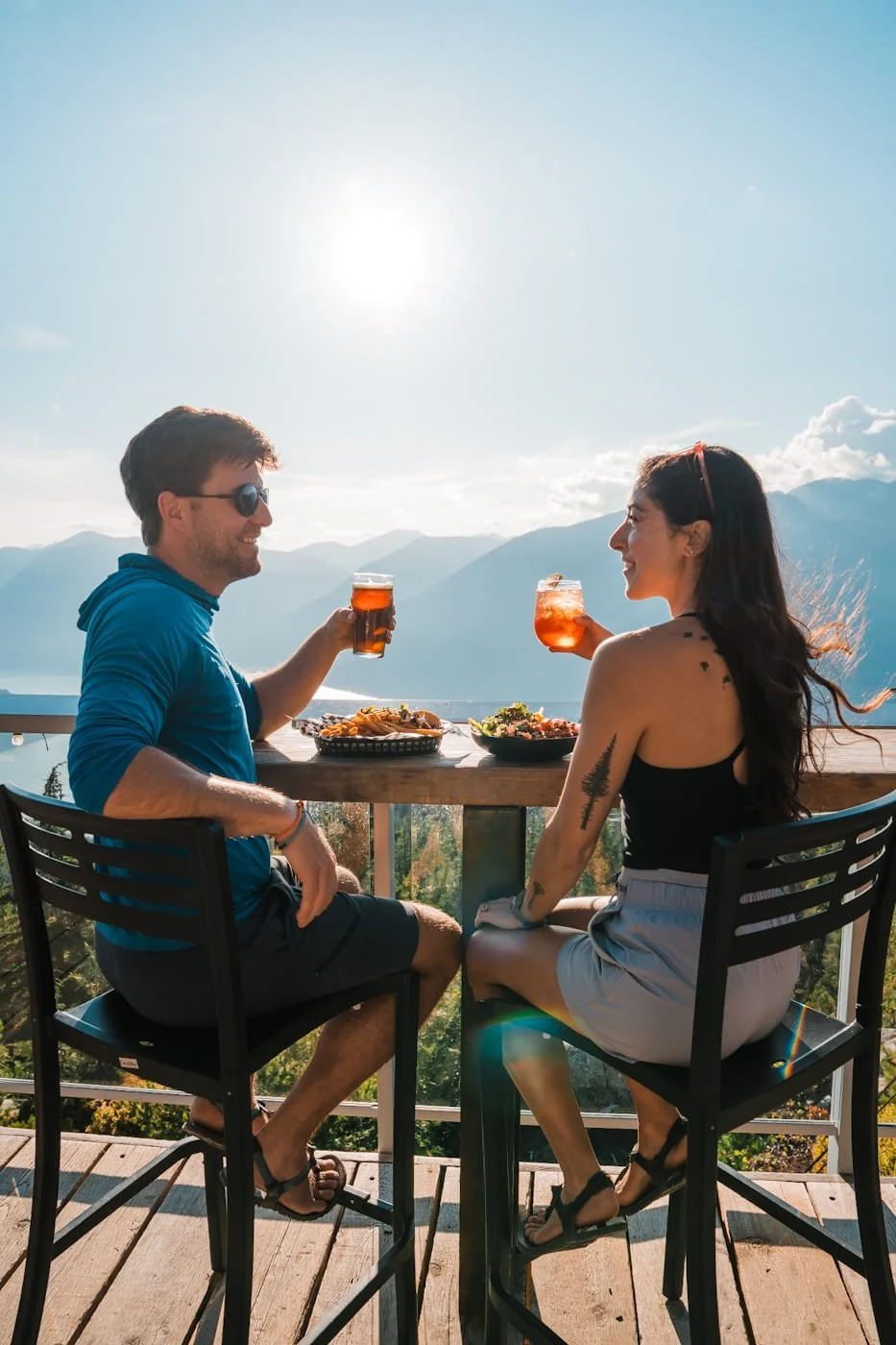 Man and woman enjoying dinner and drinks on the Sea to Sky Gondola patio