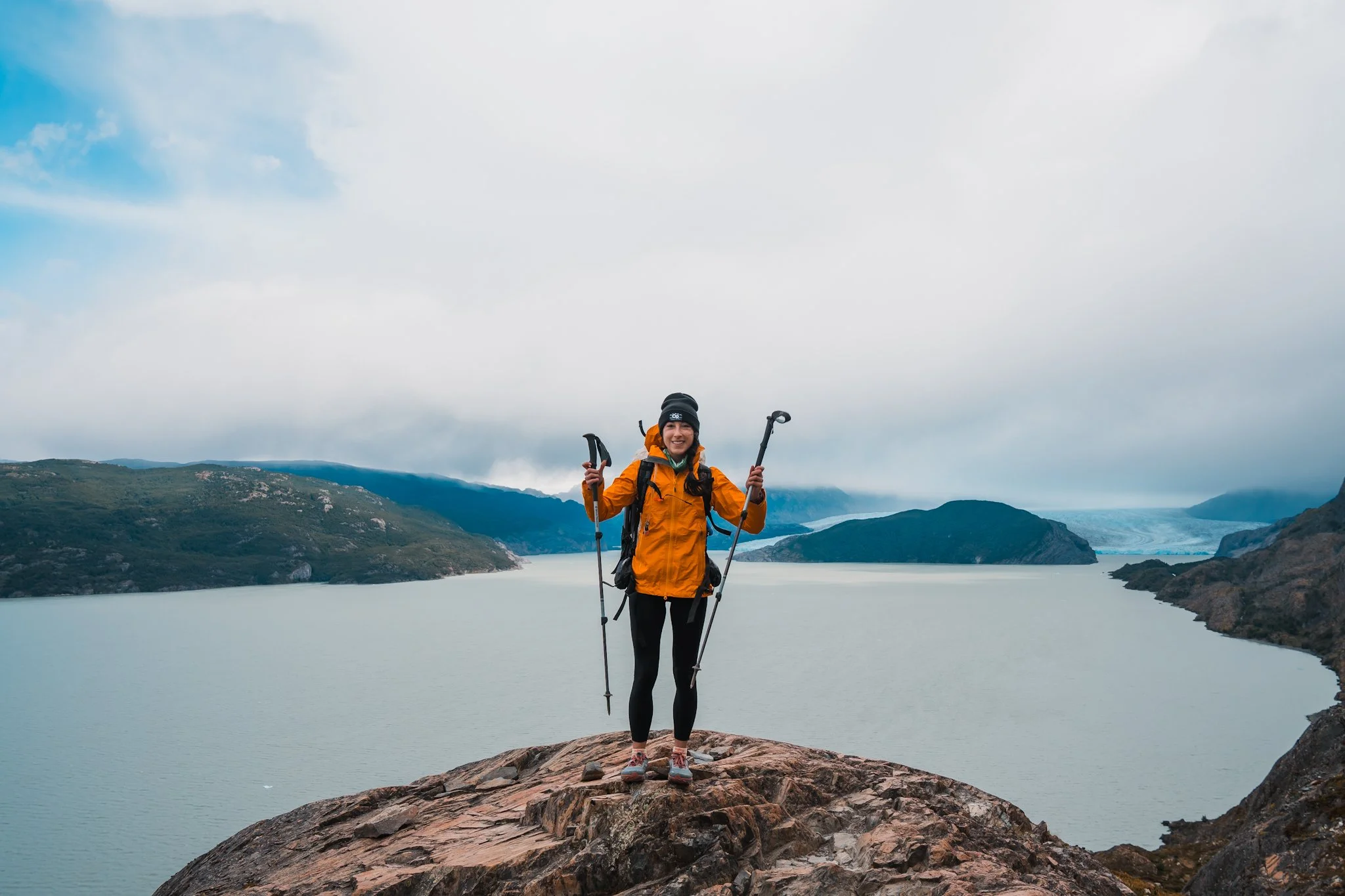 a women in patagonia wearing a bright yellow rain jacket on the trail