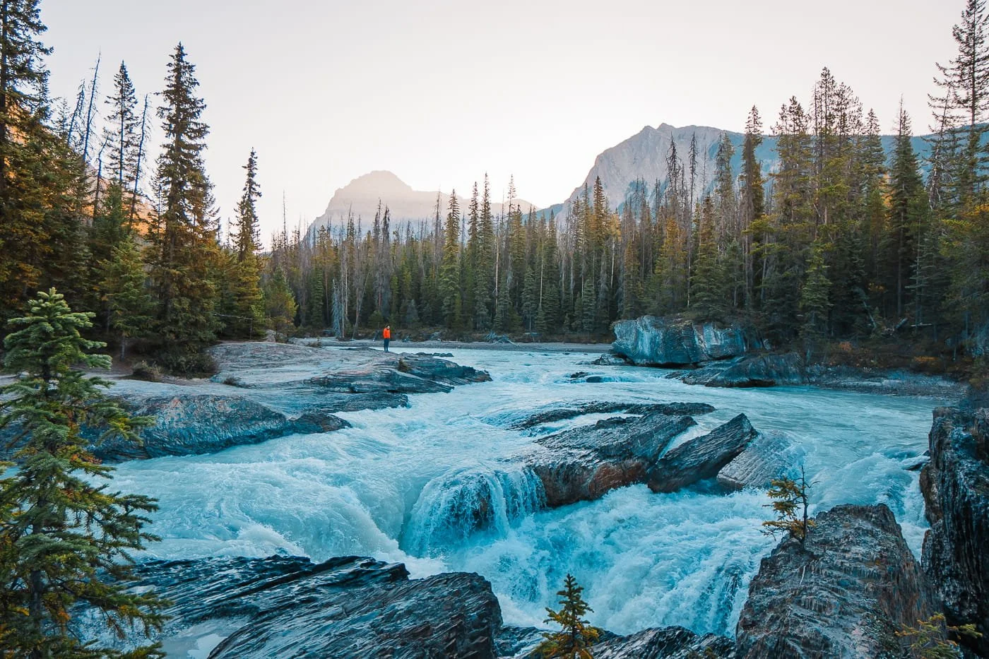 man standing on rock bar at Natural Bridge near Emerald Lake in Yoho National Park
