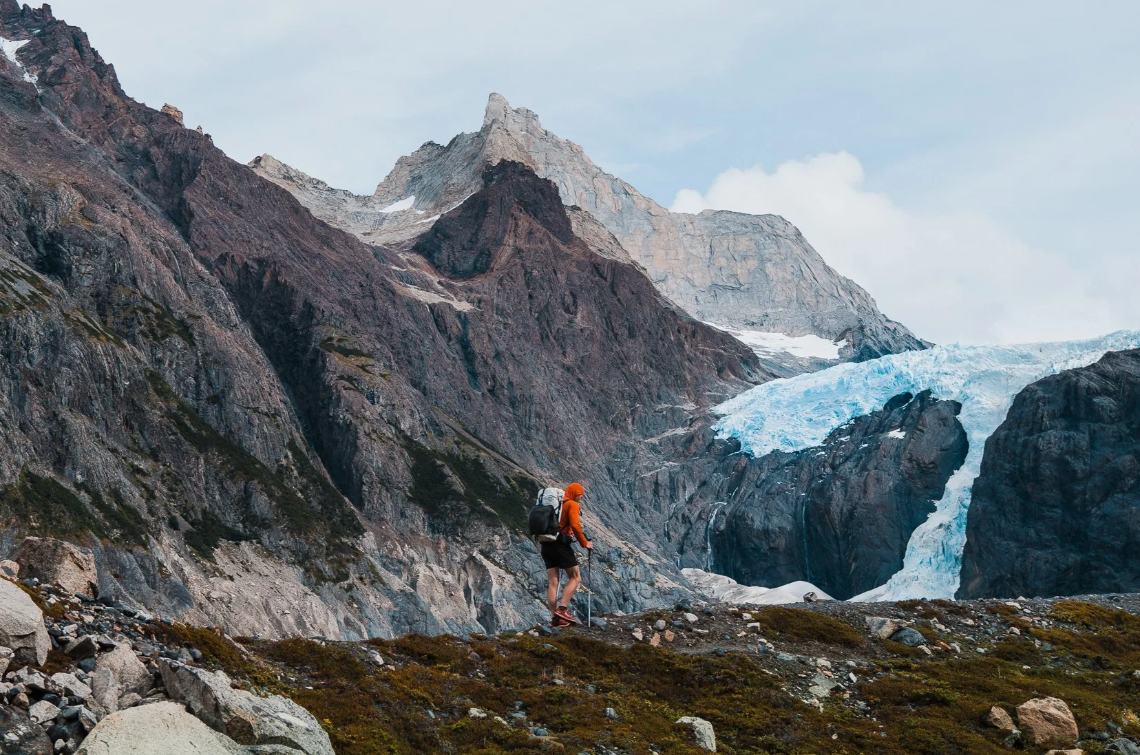 A backpacker hiking on a trail in patagonia with mountains in the background