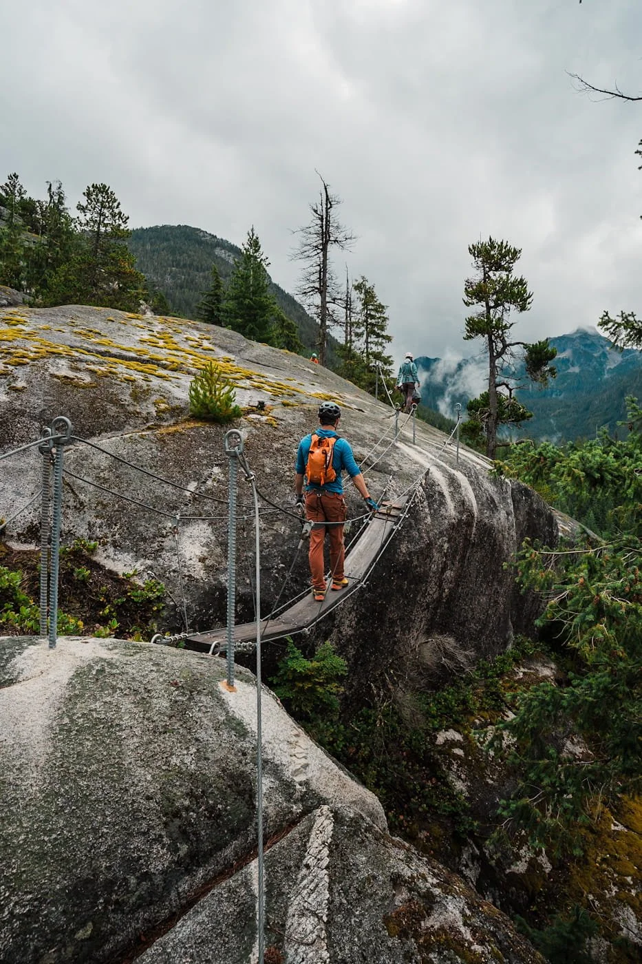  man walking across suspension bridge on the Squamish Via Ferrata 