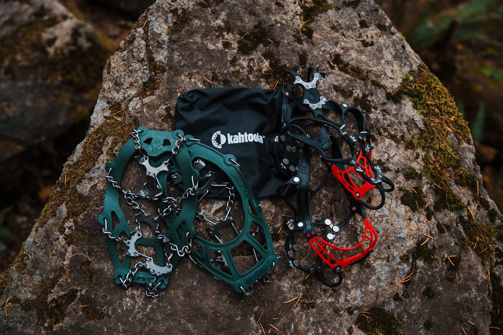 two pairs of kahtoola microspikes laying on a rock