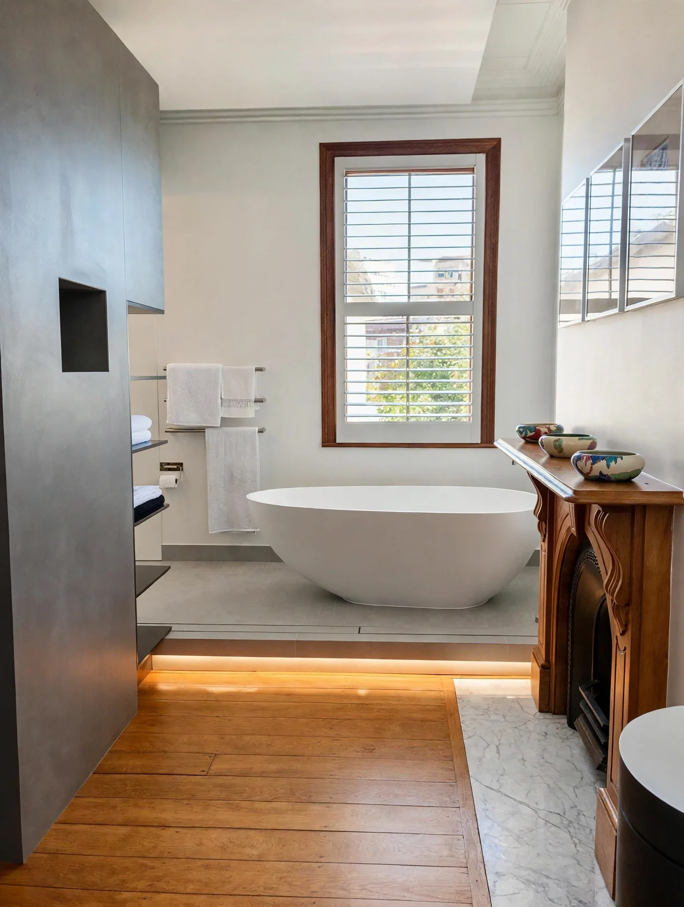 Freestanding bathtub beside original cast-iron fireplace mantle, heritage terrace ensuite