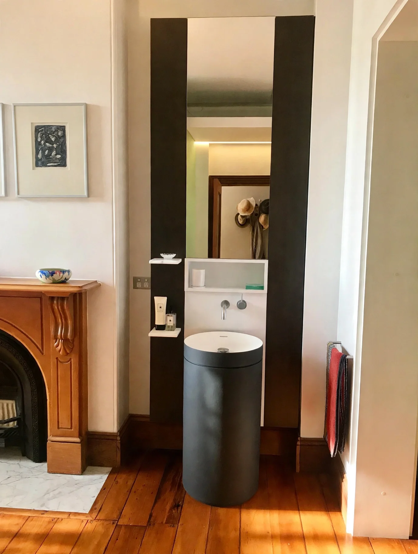 Ensuite bathroom with sculptural basin beside original timber fireplace mantle, Erskineville terrace