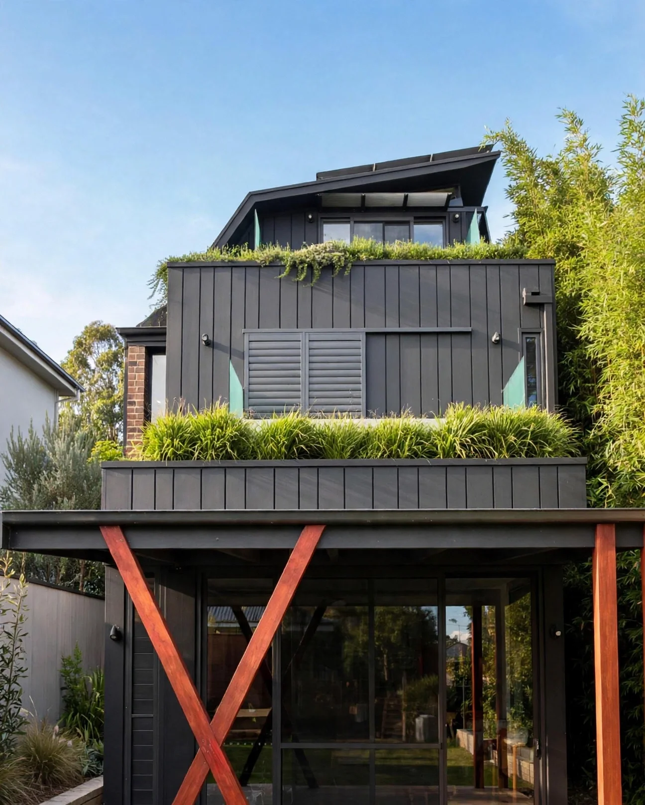 Rear addition with vertical dark cladding and planted green roof terraces, Marrickville bungalow renovation