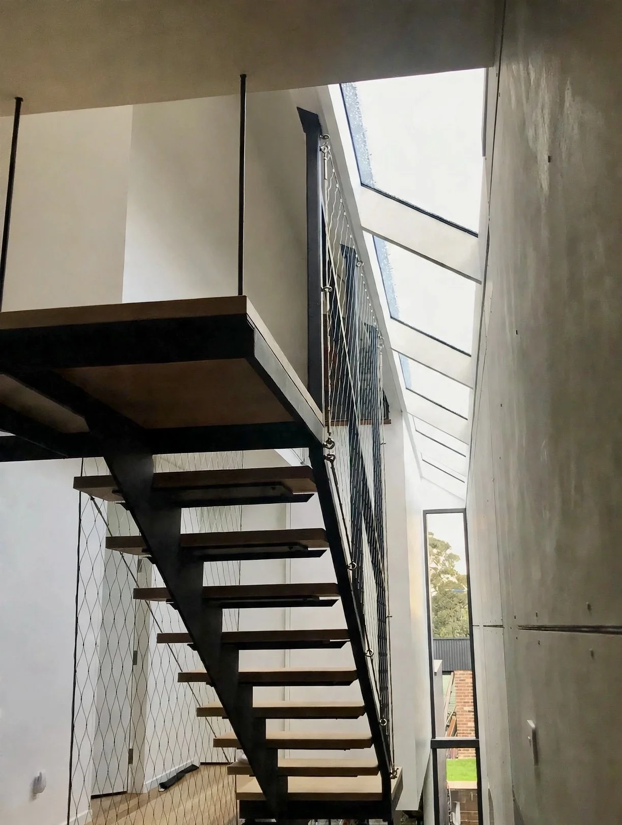 Floating steel, skylight and timber staircase with woven cable balustrade, Marrickville bungalow addition