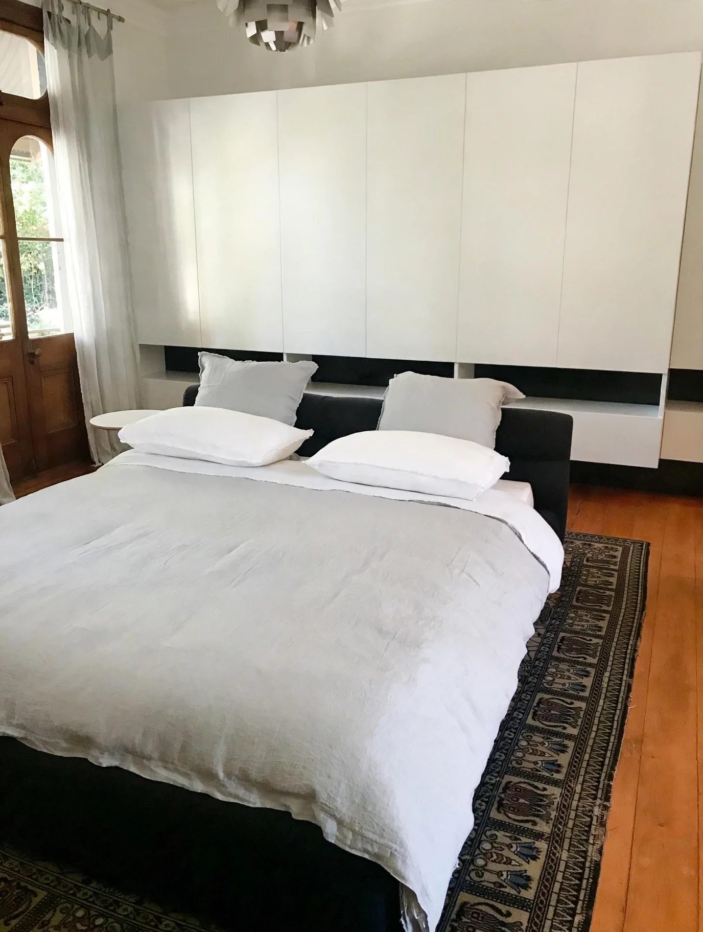Main bedroom with built-in wardrobe joinery and original timber door, Erskineville Victorian terrace