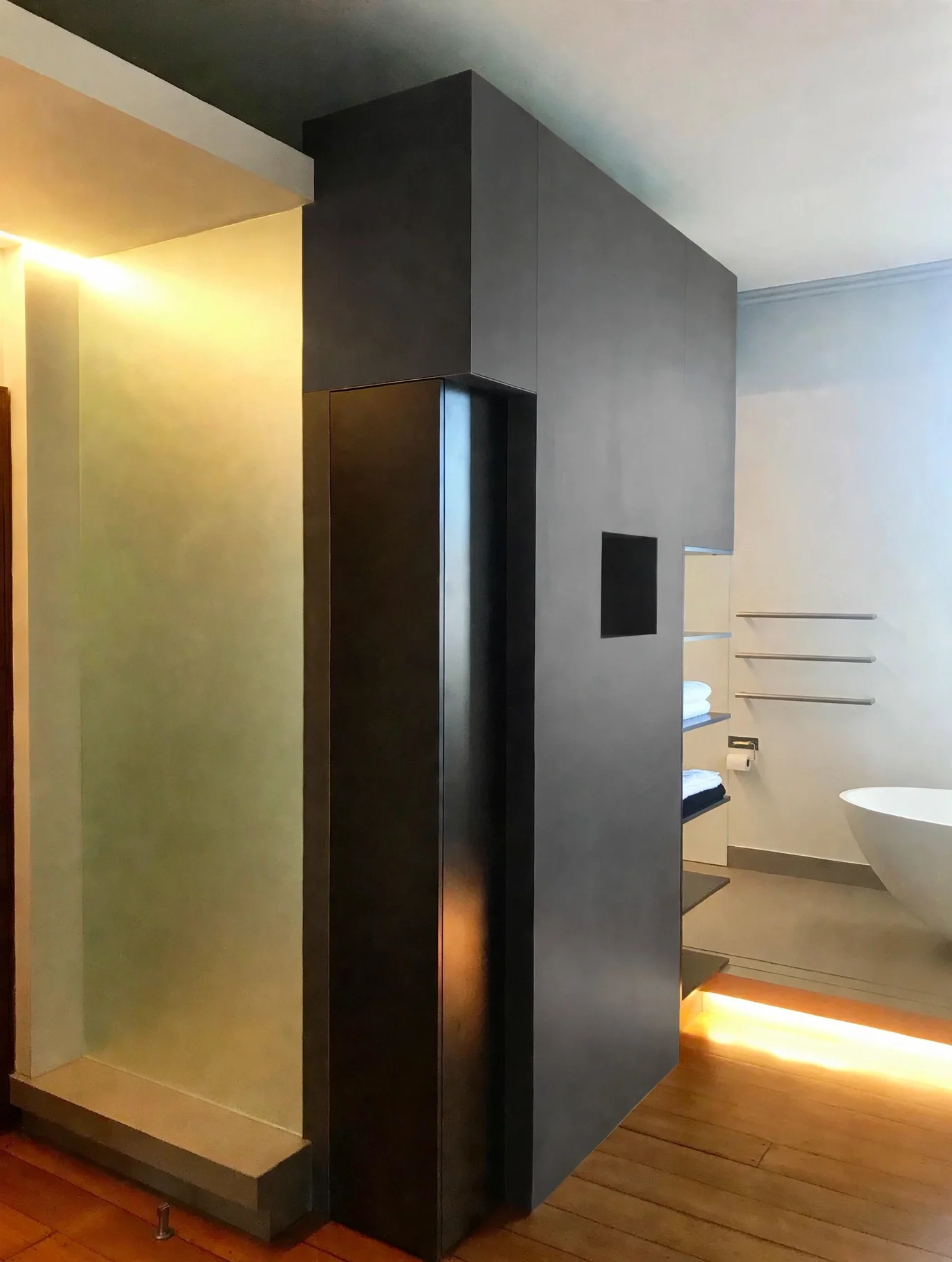 Freestanding bathtub on raised platform with underlighting, steel partition wall, heritage terrace ensuite