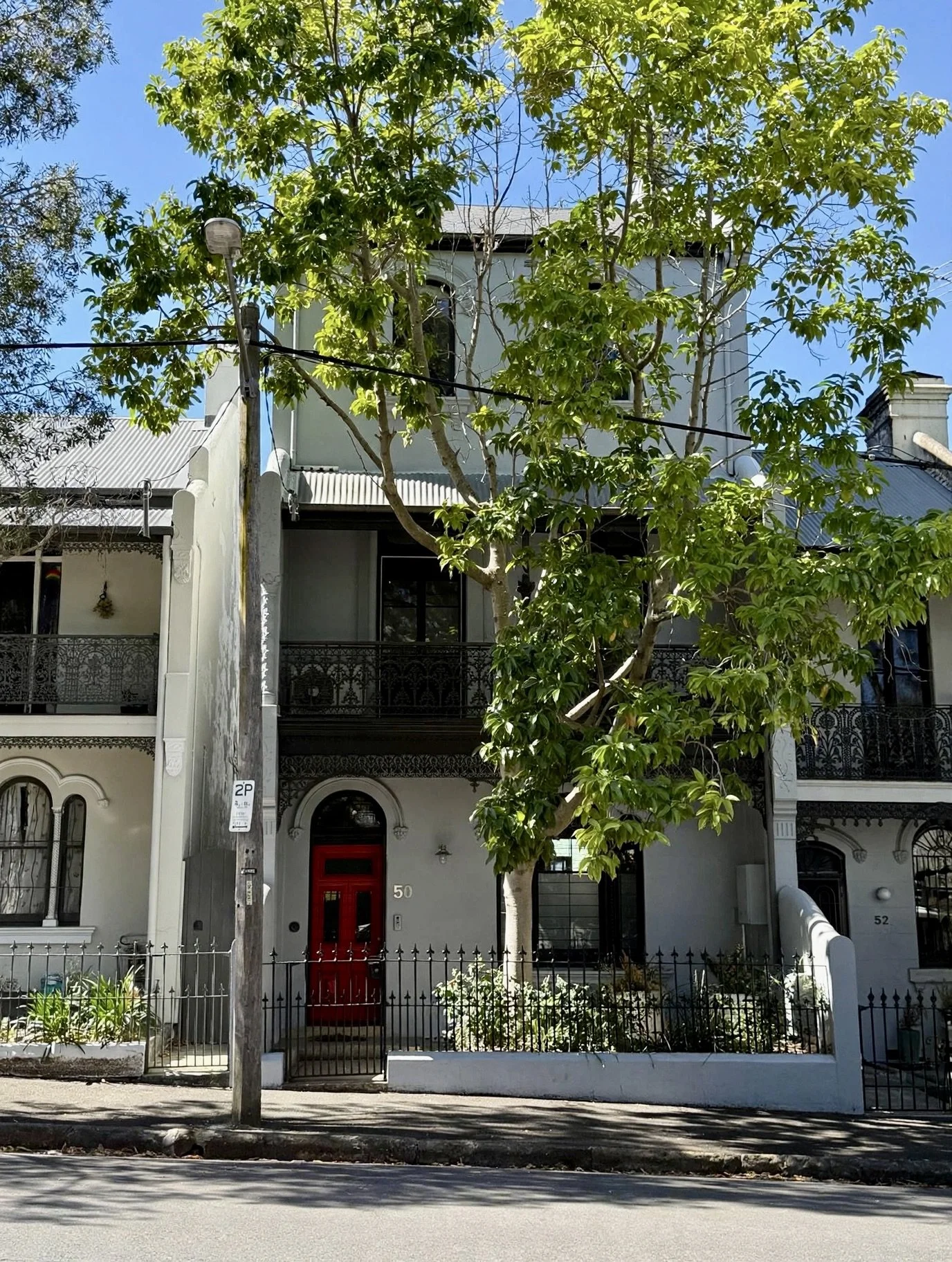 Street view of the terrace's restored facade and arched entry, Erskineville.