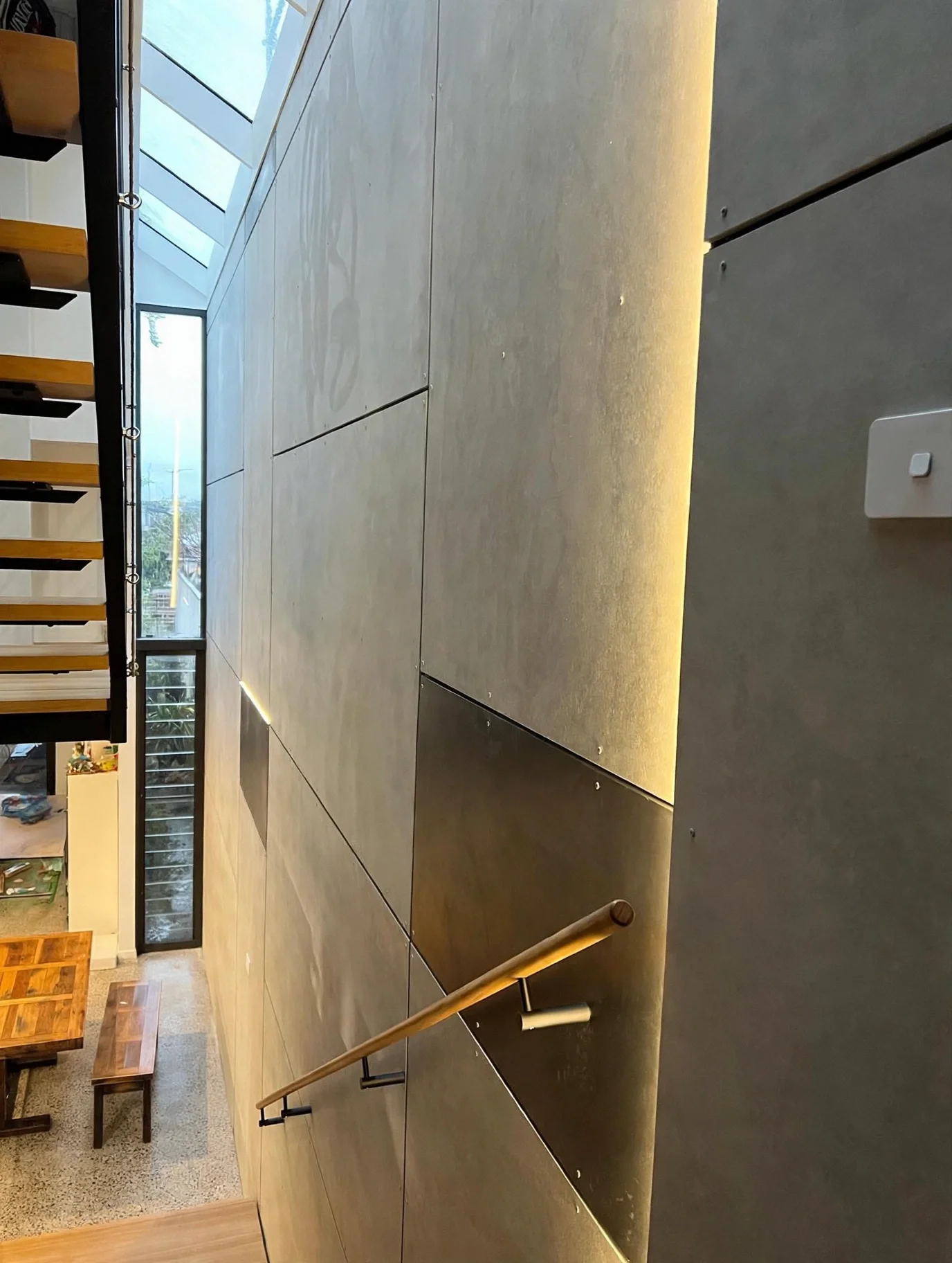 Board-formed concrete feature wall with integrated LED lighting and timber handrail detail, Marrickville bungalow staircase