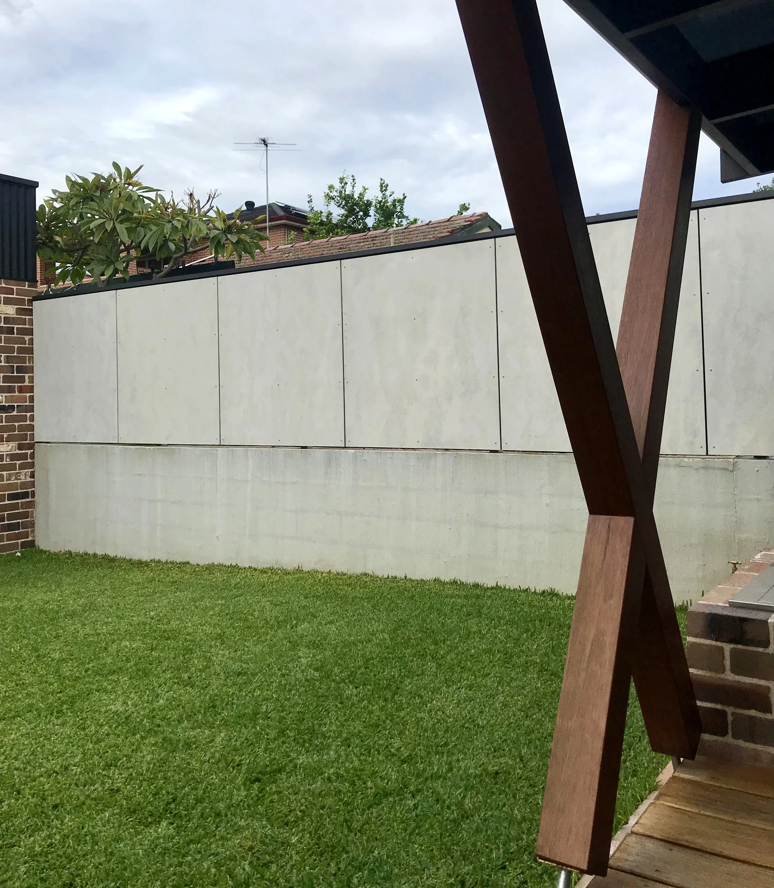 Rear garden showing precast concrete boundary treatment and timber outdoor structure, Marrickville renovation