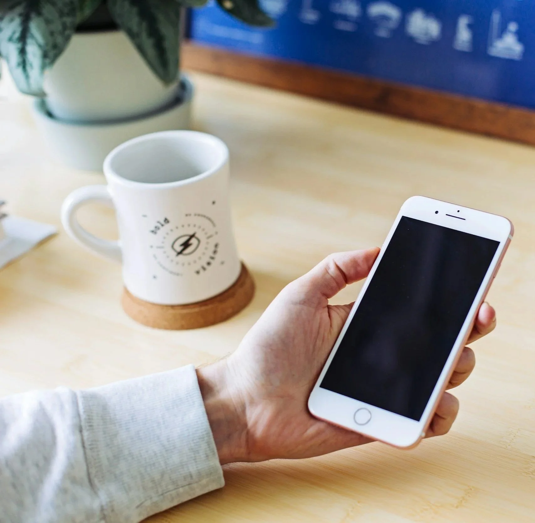 Person holding smartphone to contact general contractor for construction project