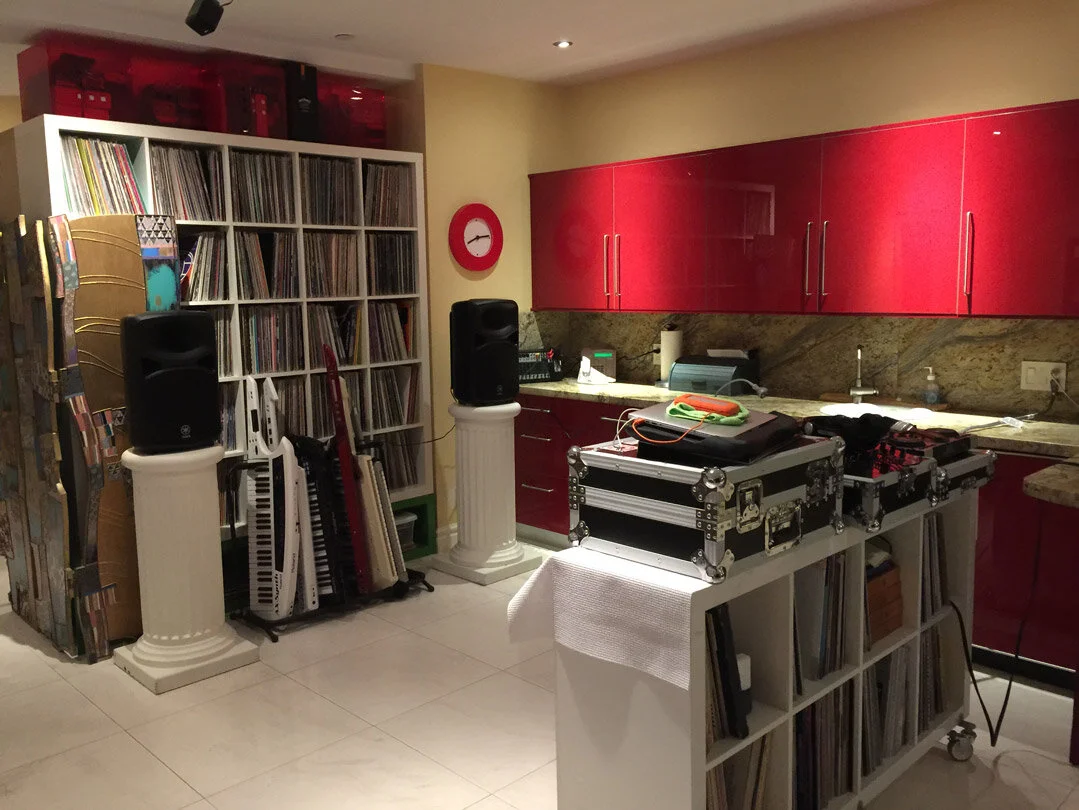 Home music studio with vinyl records, keyboards, red cabinets, and DJ equipment. Hashmoder (Omar Hash) (Omar Hashim)