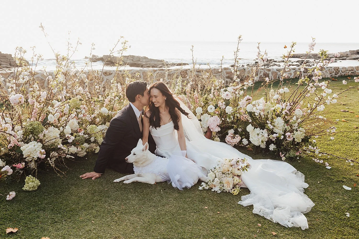     Luxury destination wedding couple relaxing on tropical lawn with floral installations in Hawaii