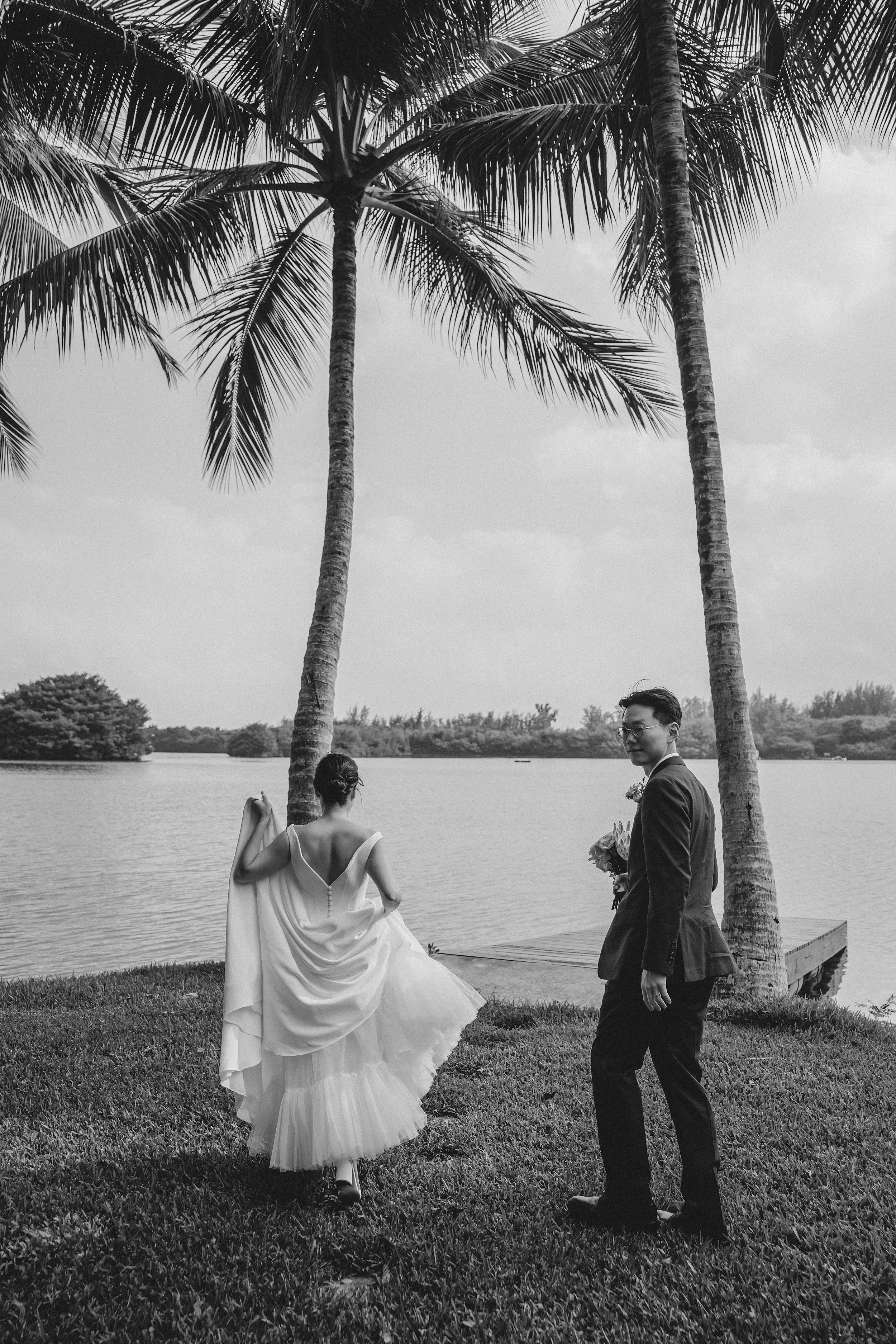     Black-and-white wedding portrait captured beneath palm trees in Hawaii