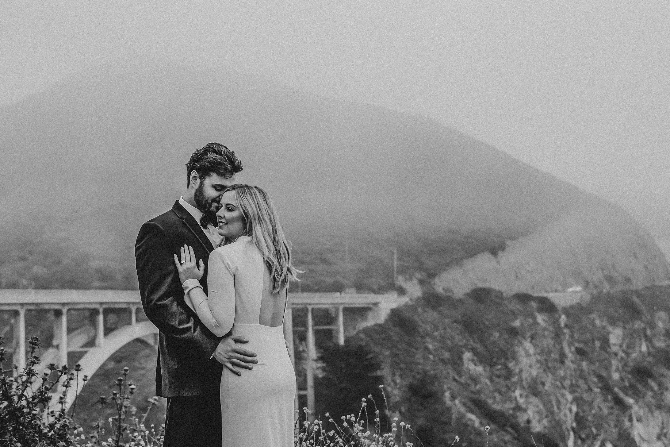     Romantic black-and-white Big Sur wedding portrait with mountain views and iconic Bixby Bridge backdrop