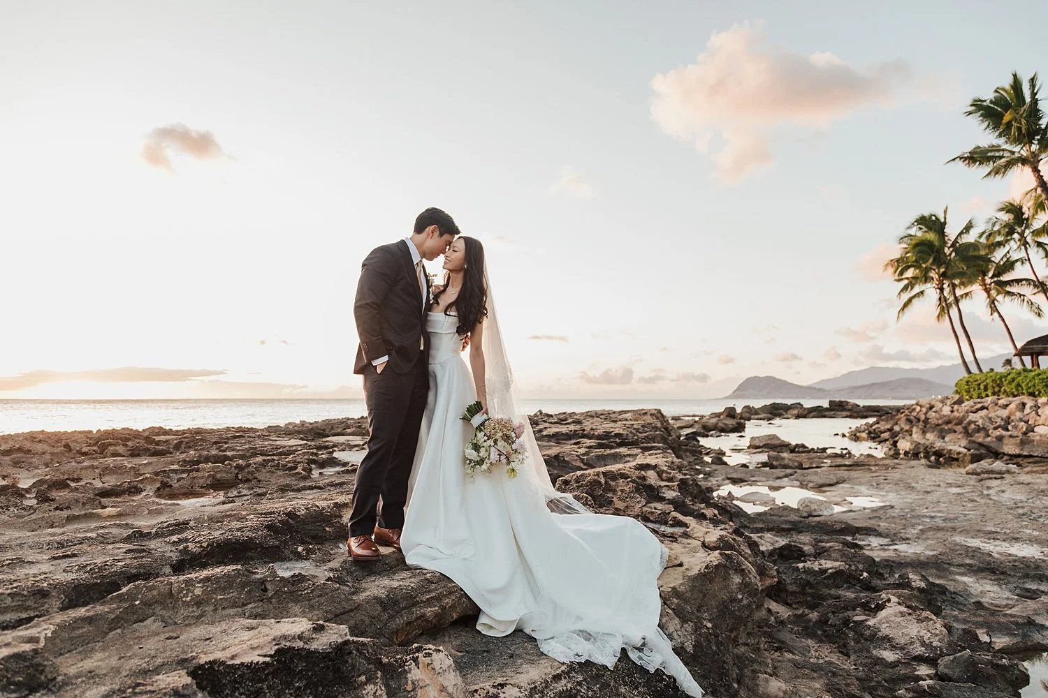     Romantic bride and groom portraits on the rocky coastline of Hawaii at sunset