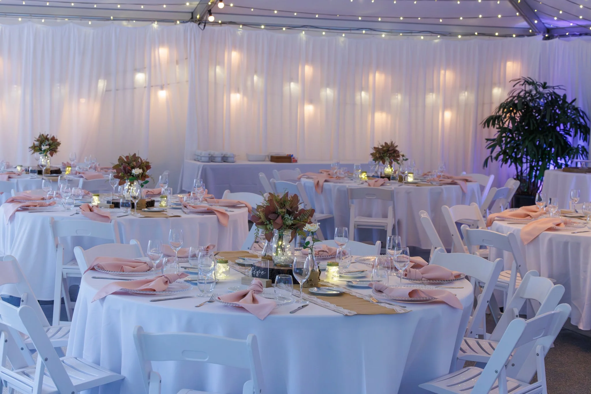 All-inclusive summer wedding reception in a marquee at In The Grove Queensland with round tables and soft styling
