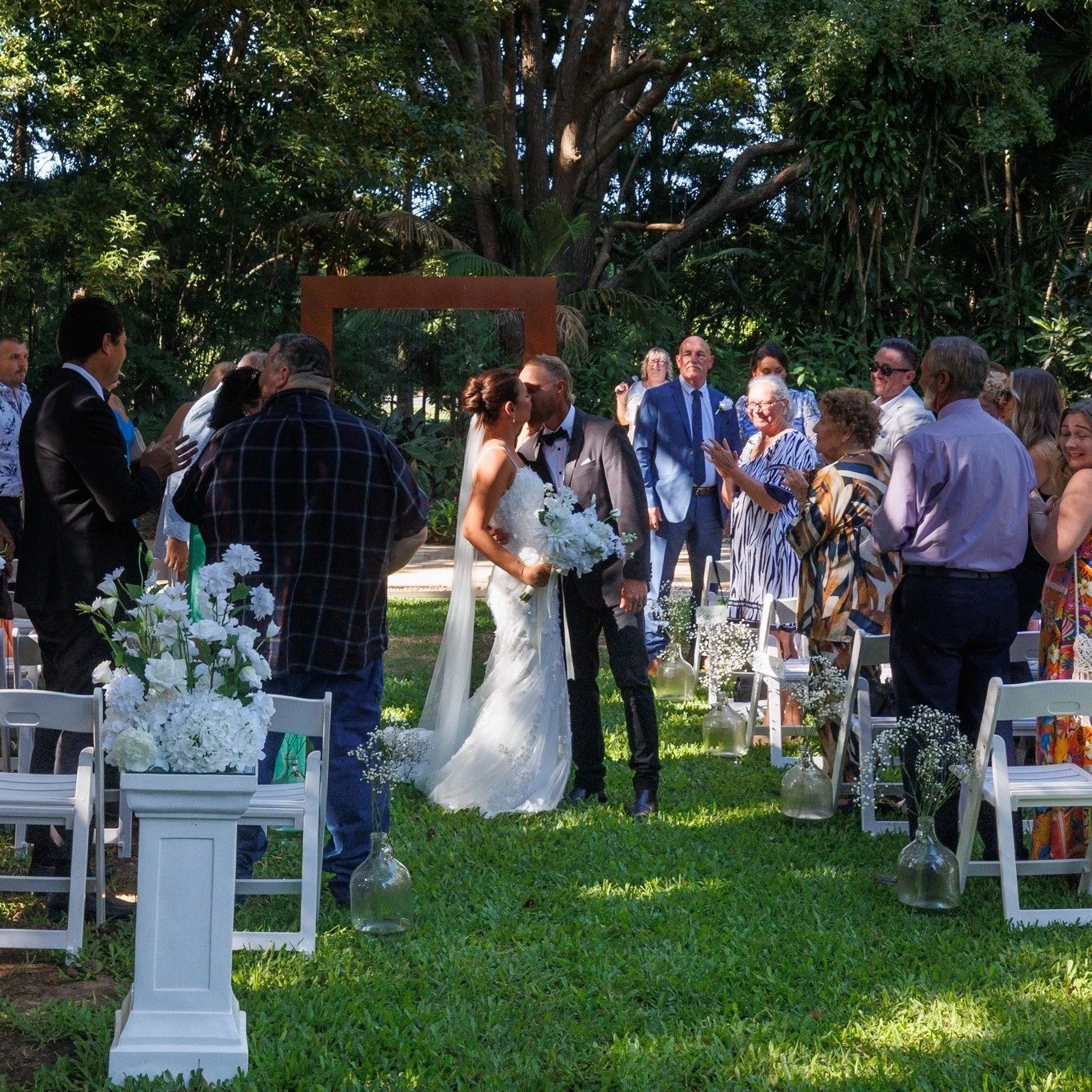 Kayla &amp; Mitch | First Kiss | In The Grove
And just like that&hellip; 🤍
Kayla &amp; Mitch sealed their vows with the sweetest first kiss beneath our corten ceremony frame, surrounded by family, lush greenery and golden afternoon light.
Their clas
