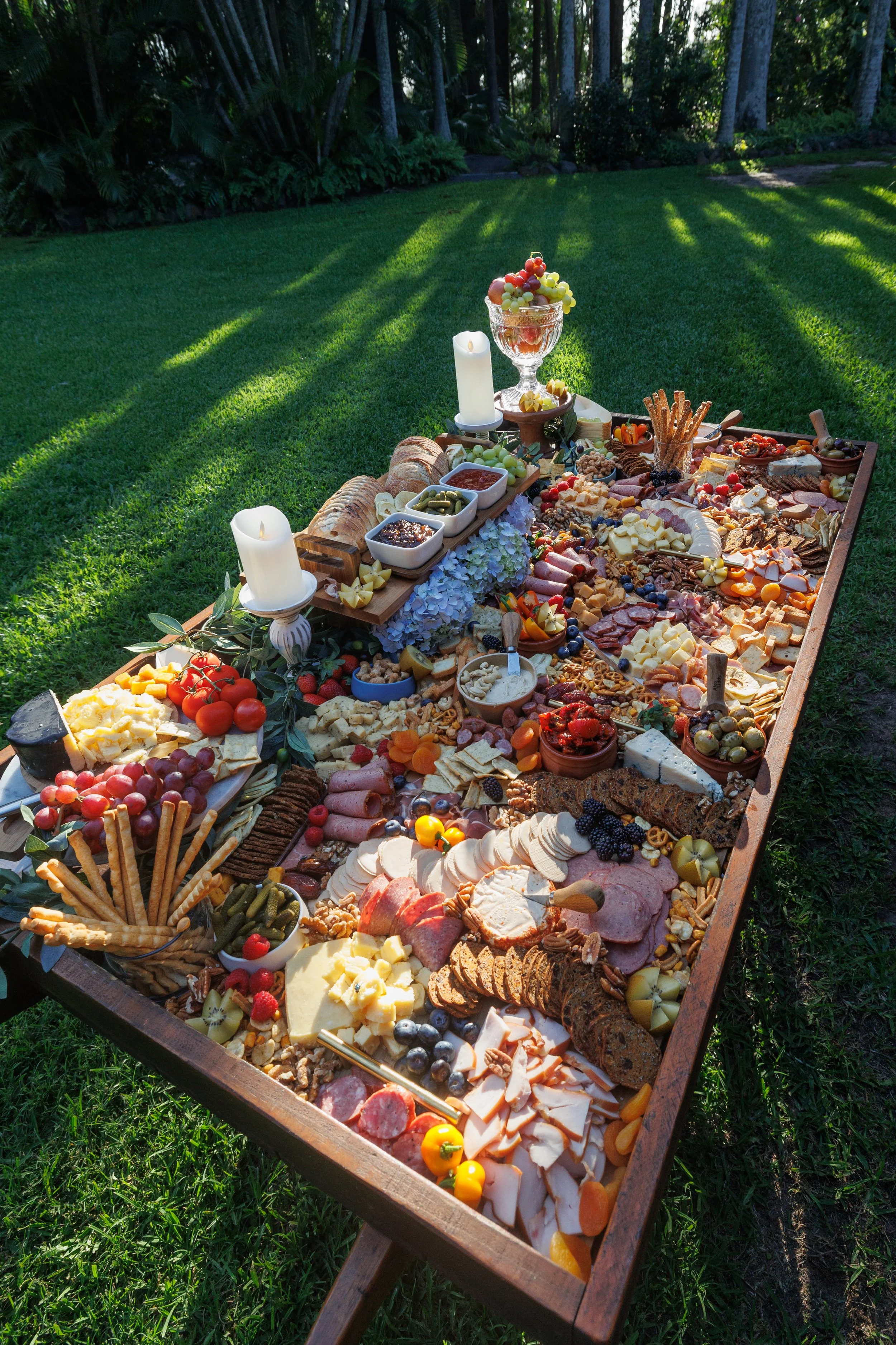 Luxury outdoor grazing table set on garden lawns, styled for a Queensland wedding reception.