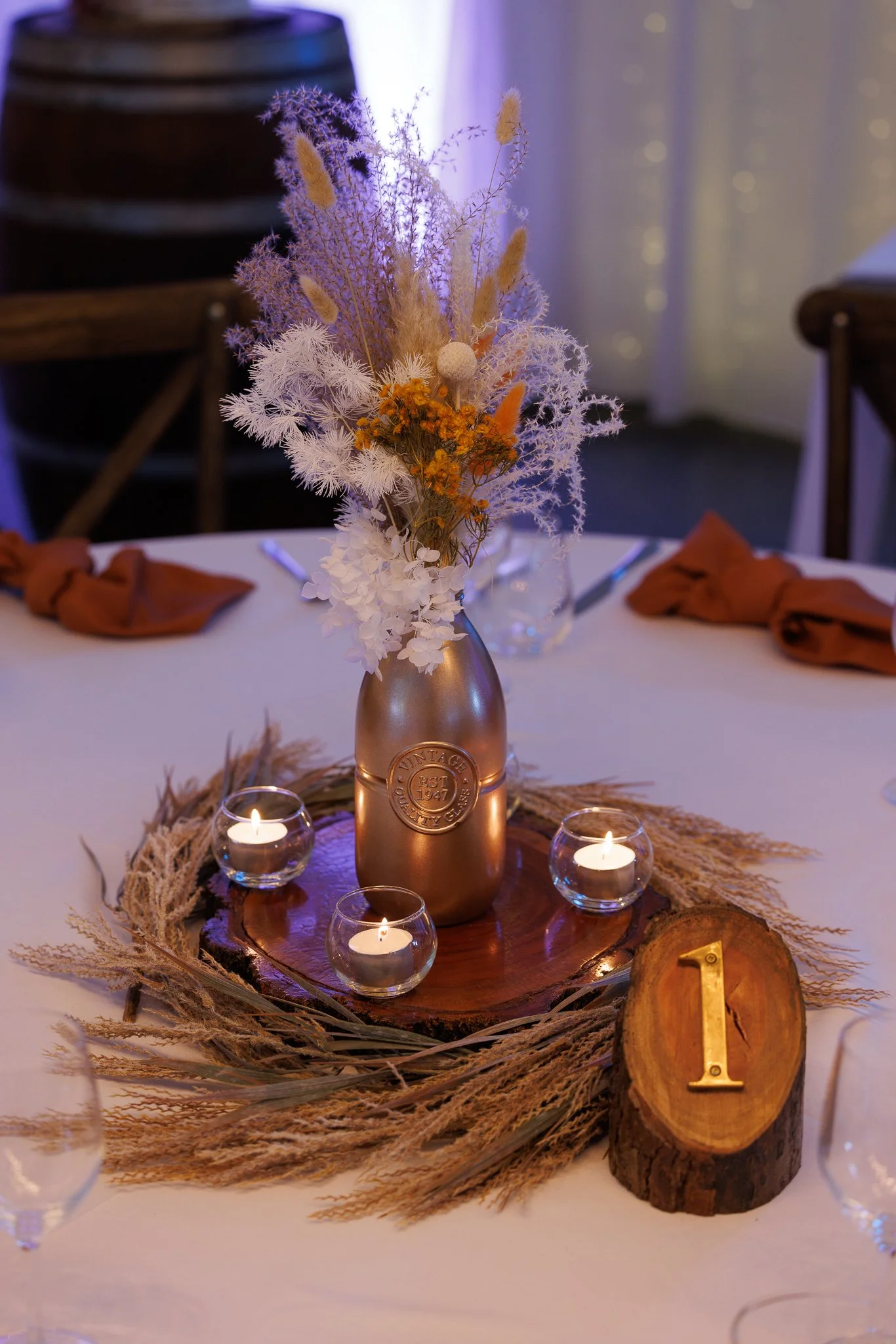 Wedding table styling with candles, florals and detailed place settings creating a warm and inviting reception space.