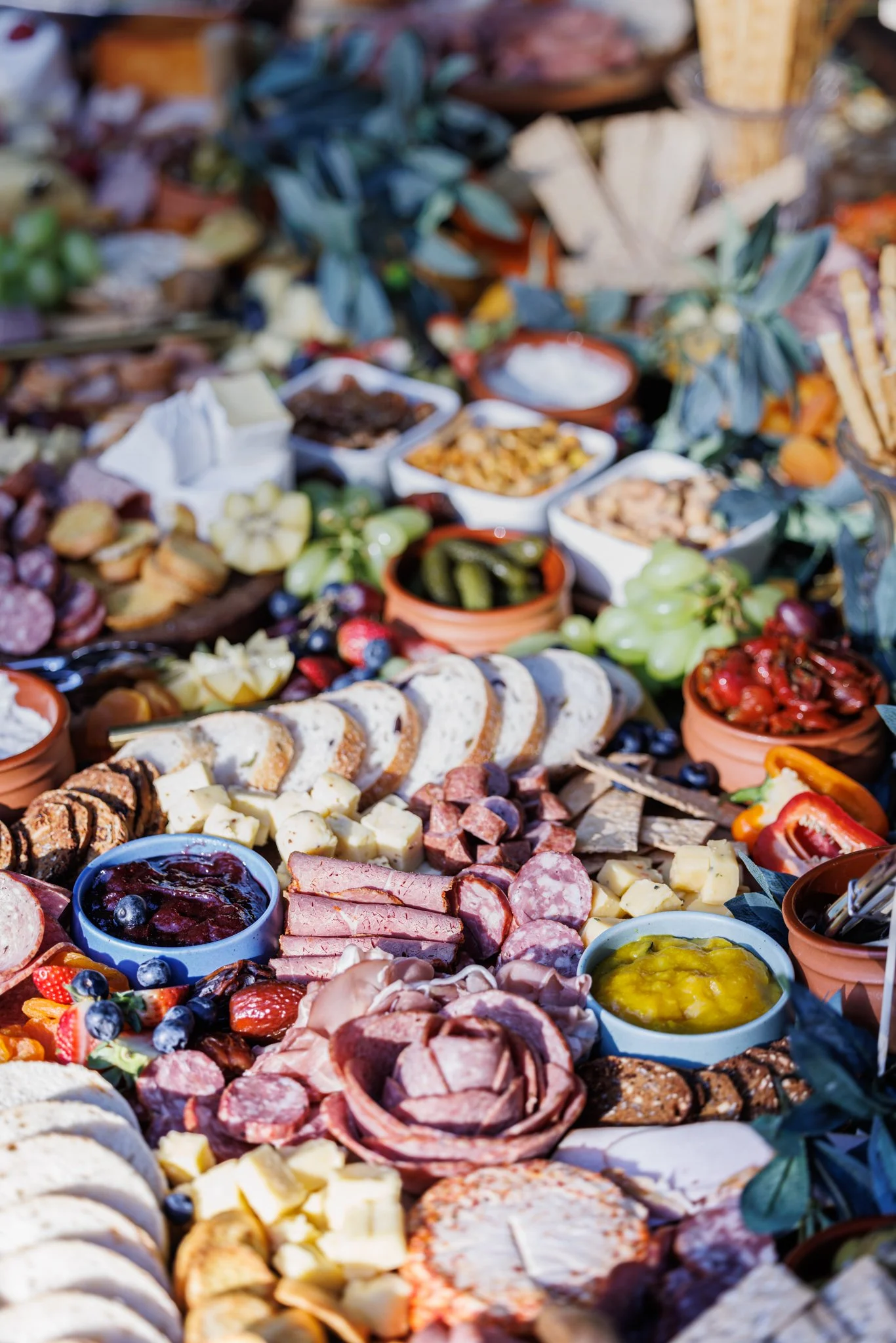 Abundant grazing table with cheeses, charcuterie and fresh fruit for a relaxed wedding reception dining experience.