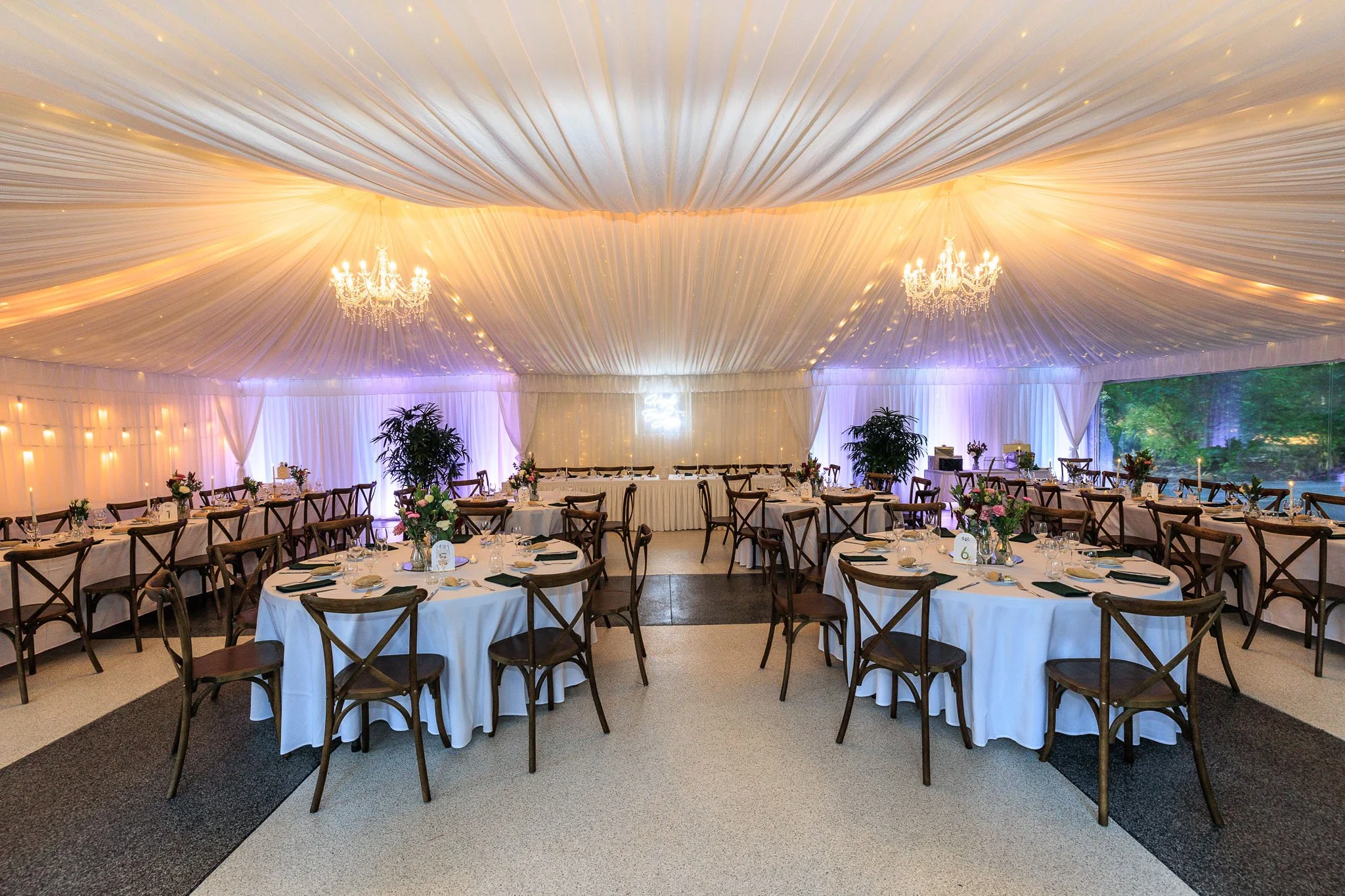 Soft draped ceiling styling inside a wedding marquee creating an elegant reception atmosphere.