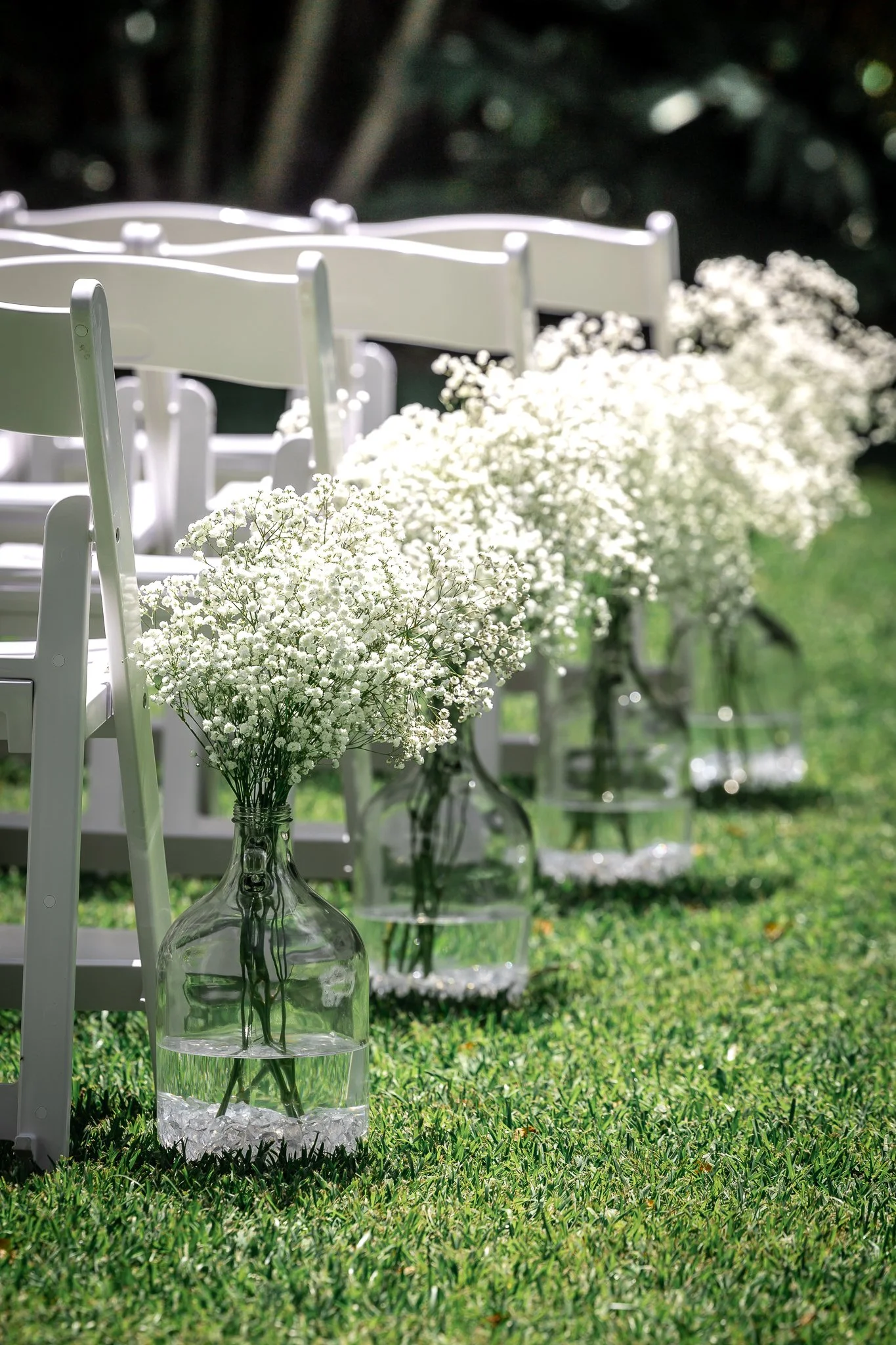 Garden wedding ceremony styling with white chairs and floral aisle