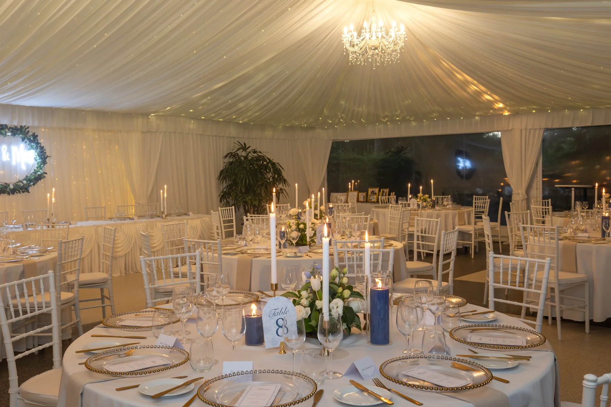 Beautifully styled wedding reception at In The Grove showcasing candlelight, chandeliers, premium table settings and timeless elegance for a Bundaberg garden wedding.