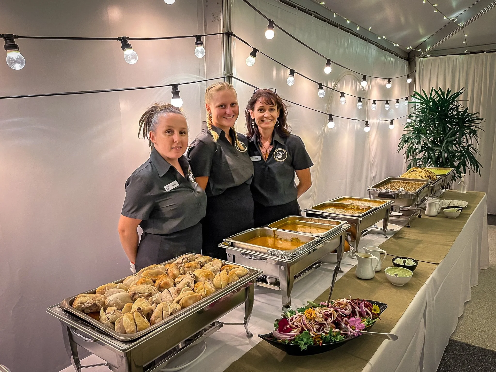 Wedding catering team presenting buffet dining options inside a marquee reception setting.