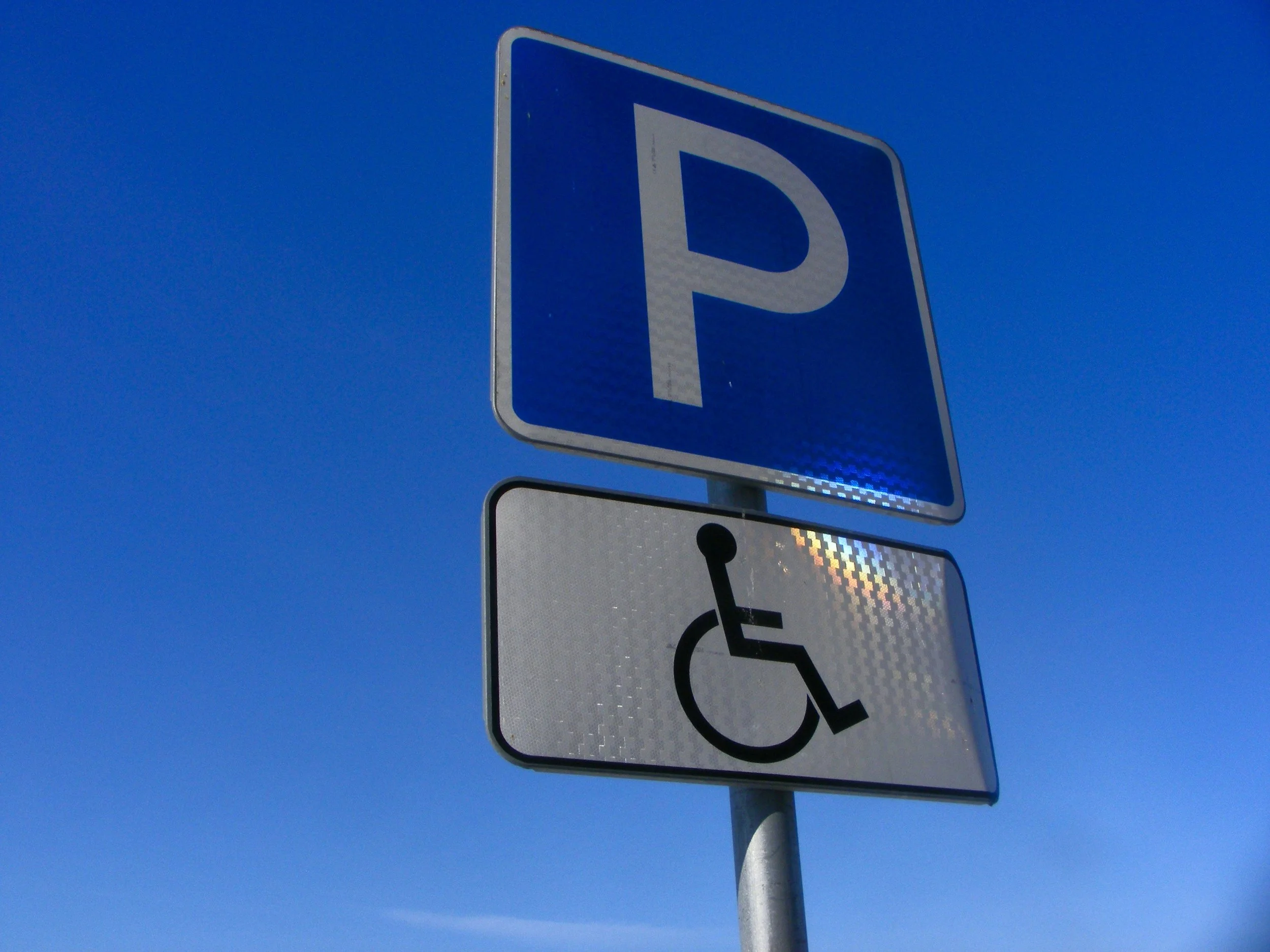 Blue parking sign with ADA insignia