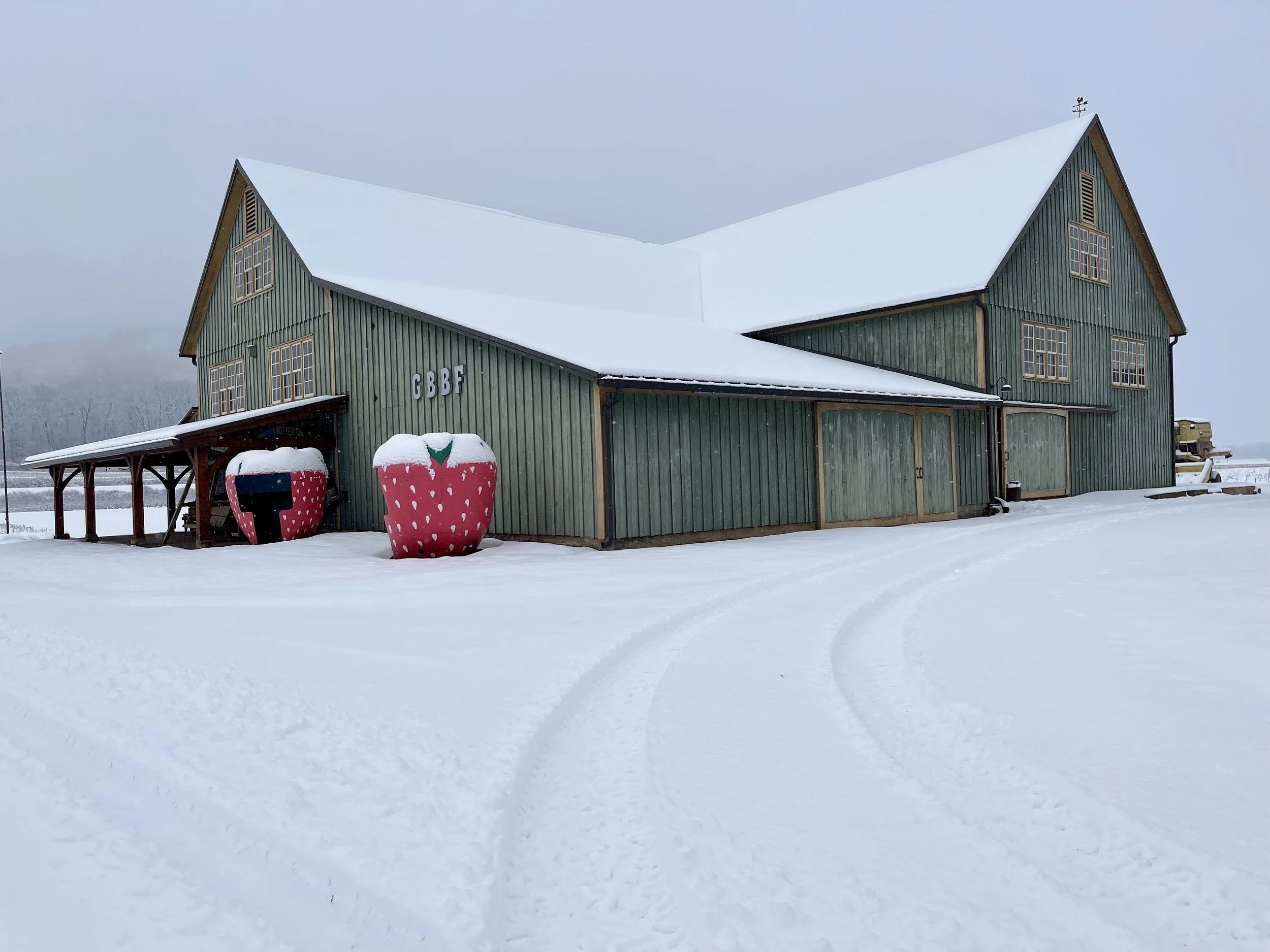 The Green barn covered in snow during the winter months.