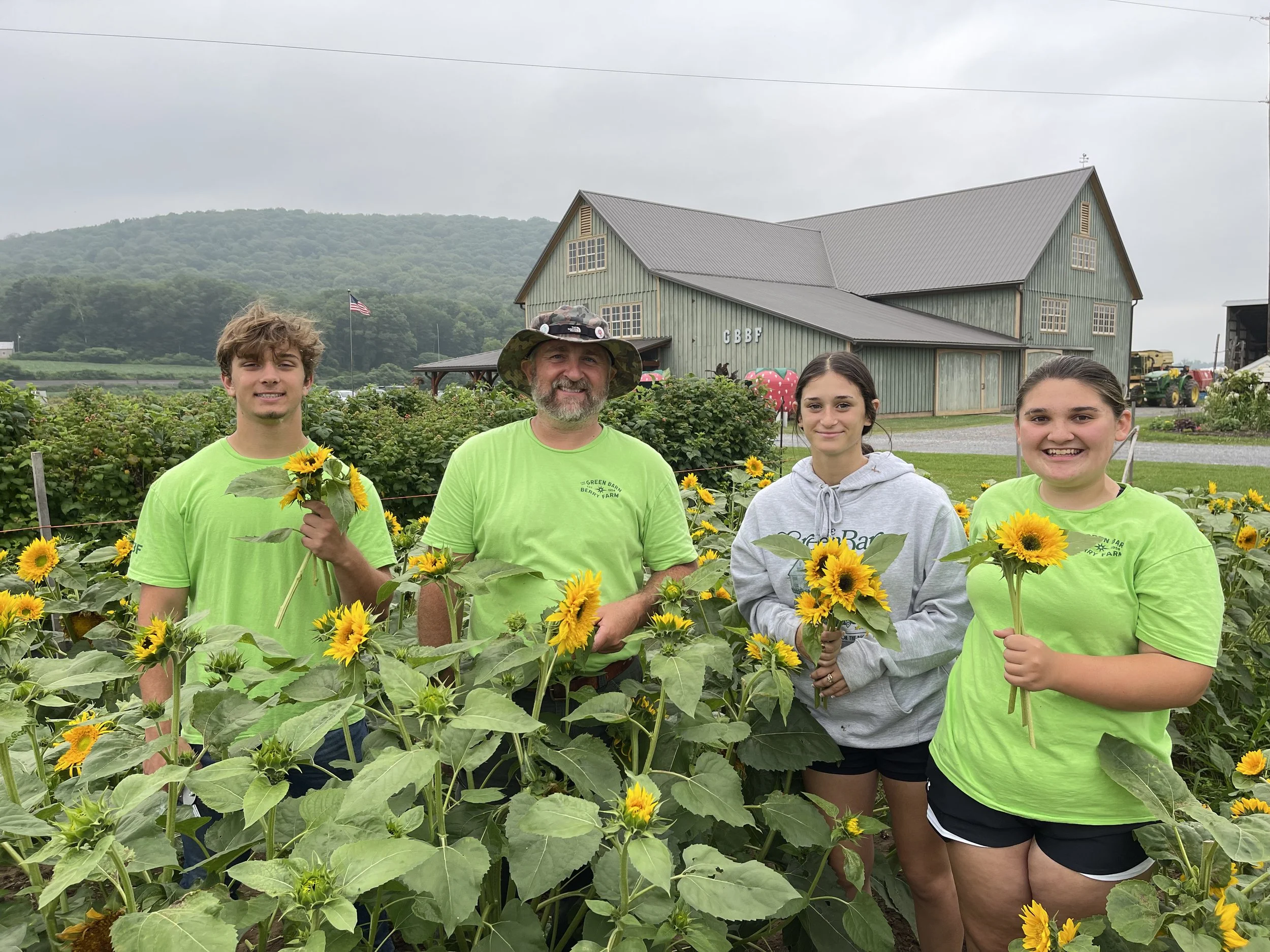 Peyton, Jarod, Faith, and Margot preparing fresh cut sunflowers.