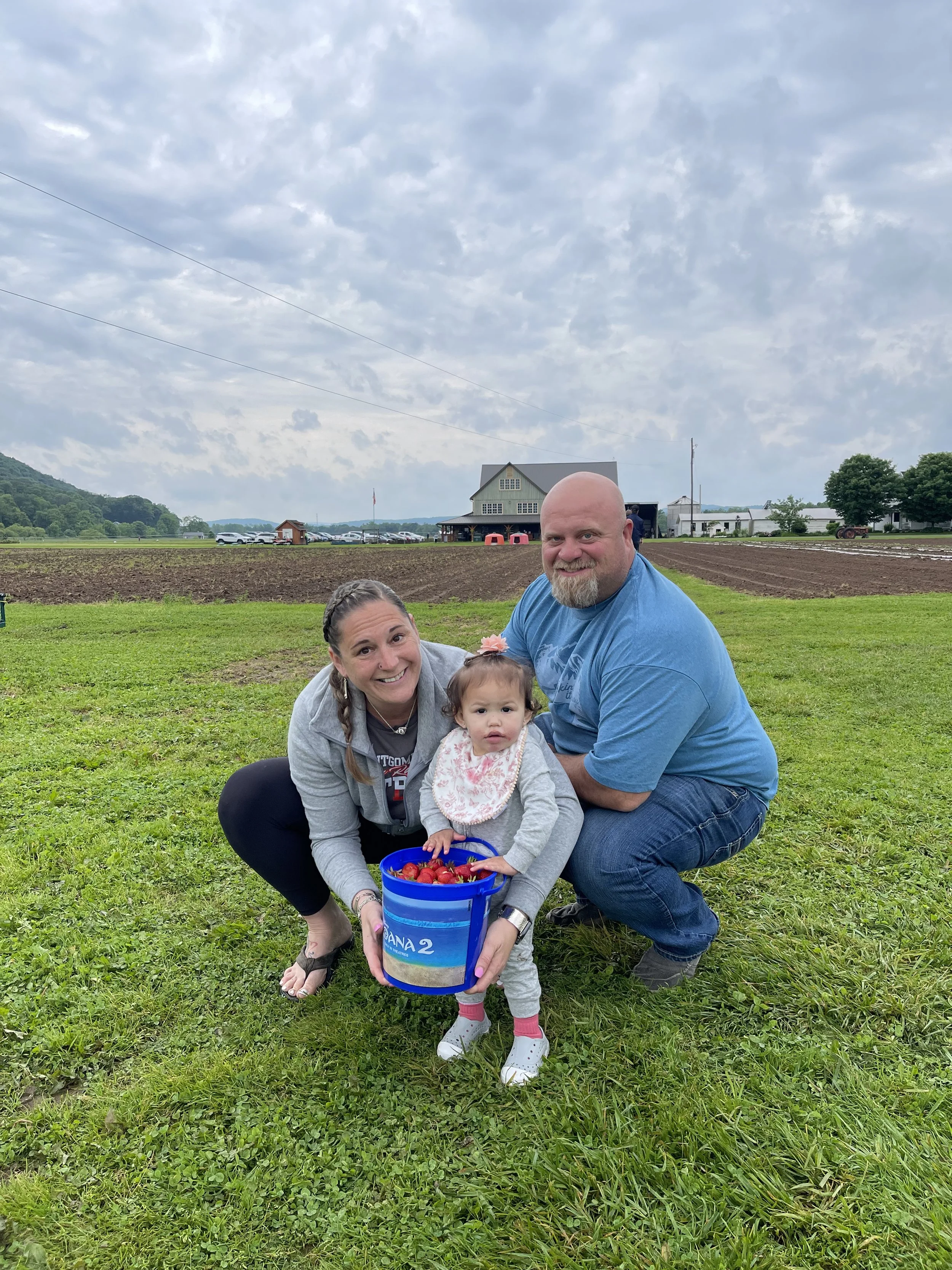 Strawberry picking with smiles all around.